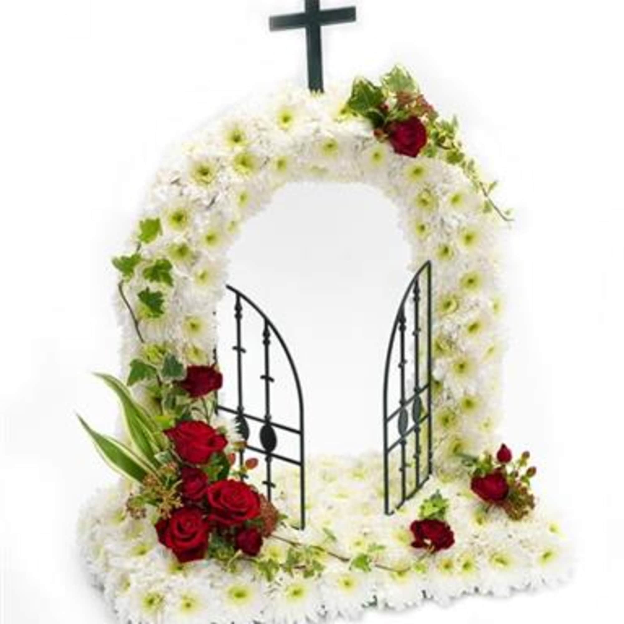 White floral funeral arch with red roses and a black cross