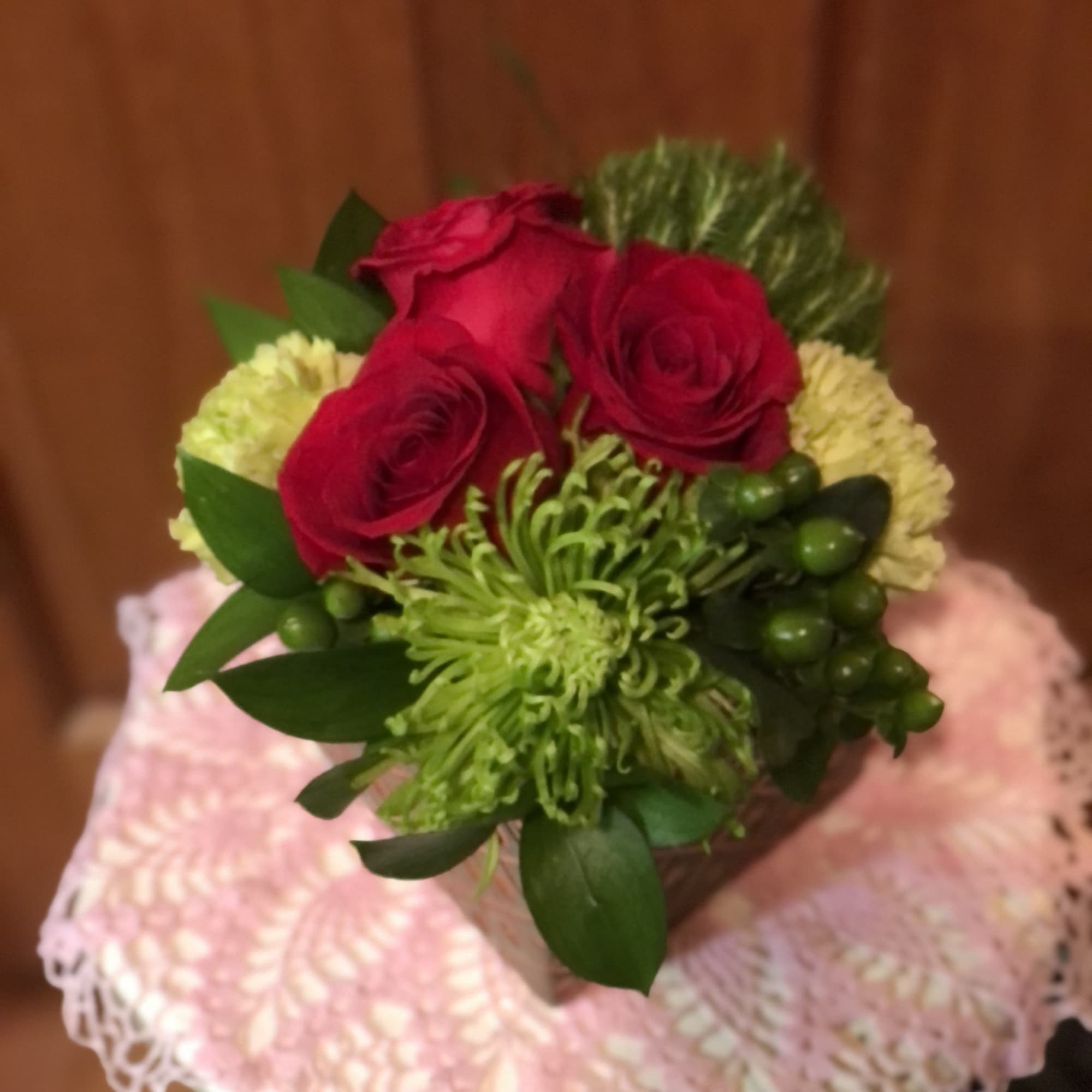 Bouquet of red roses and green chrysanthemums in a white container