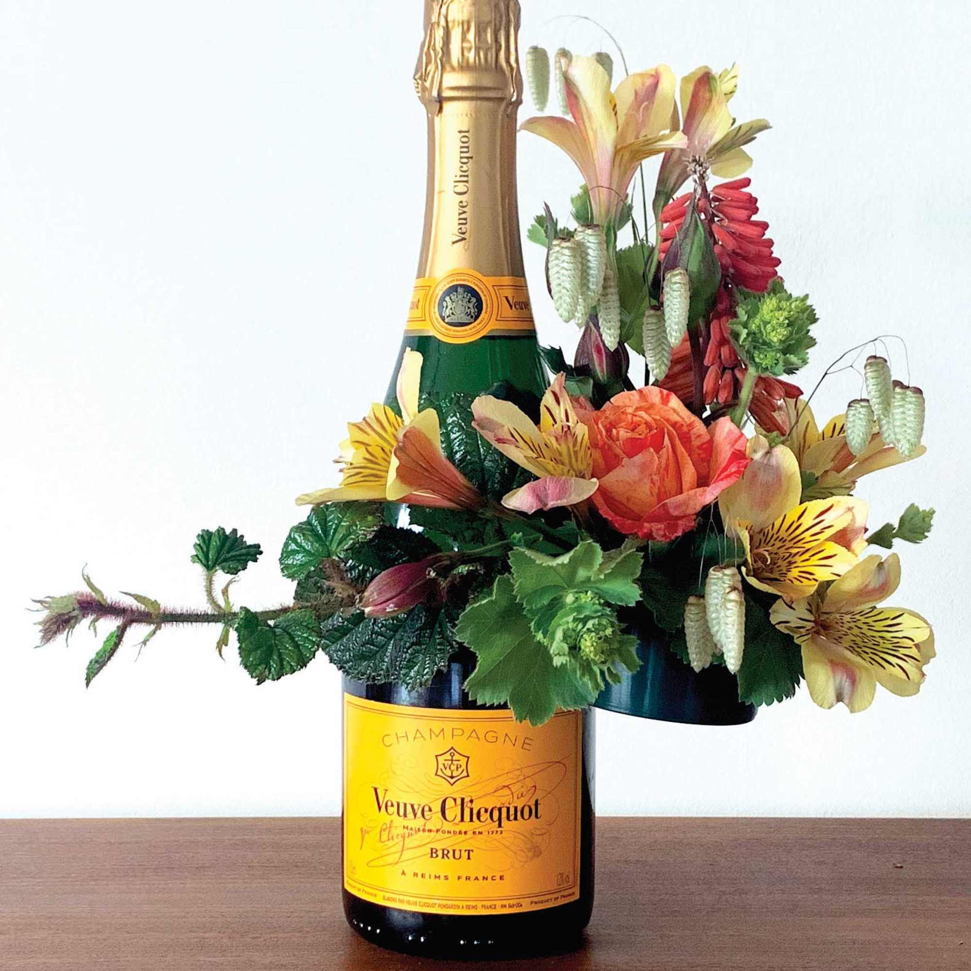 Champagne bottle with a floral arrangement attached around it