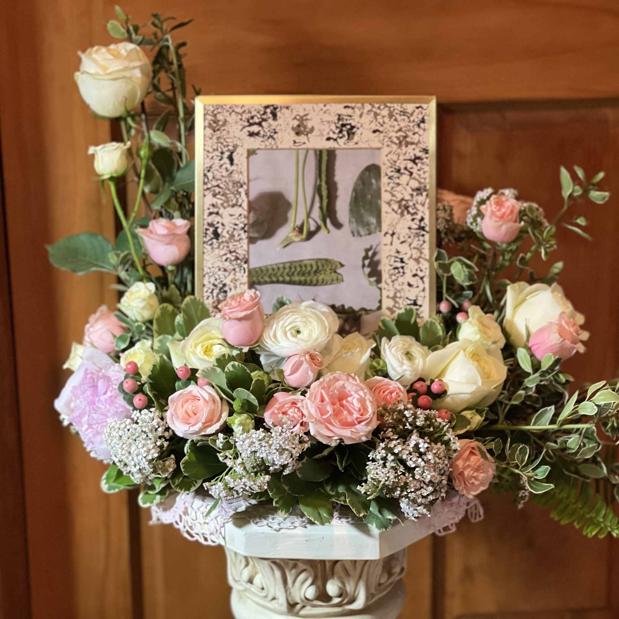 Pastel rose arrangement with a framed photo centerpiece