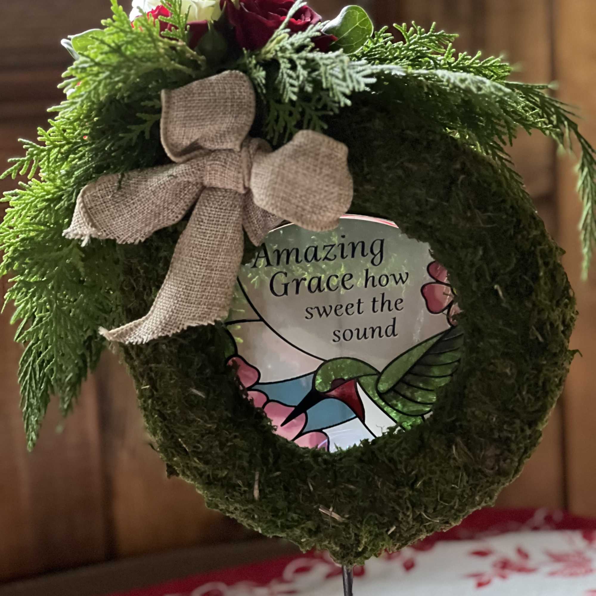 Heart-shaped moss wreath with roses and a burlap bow