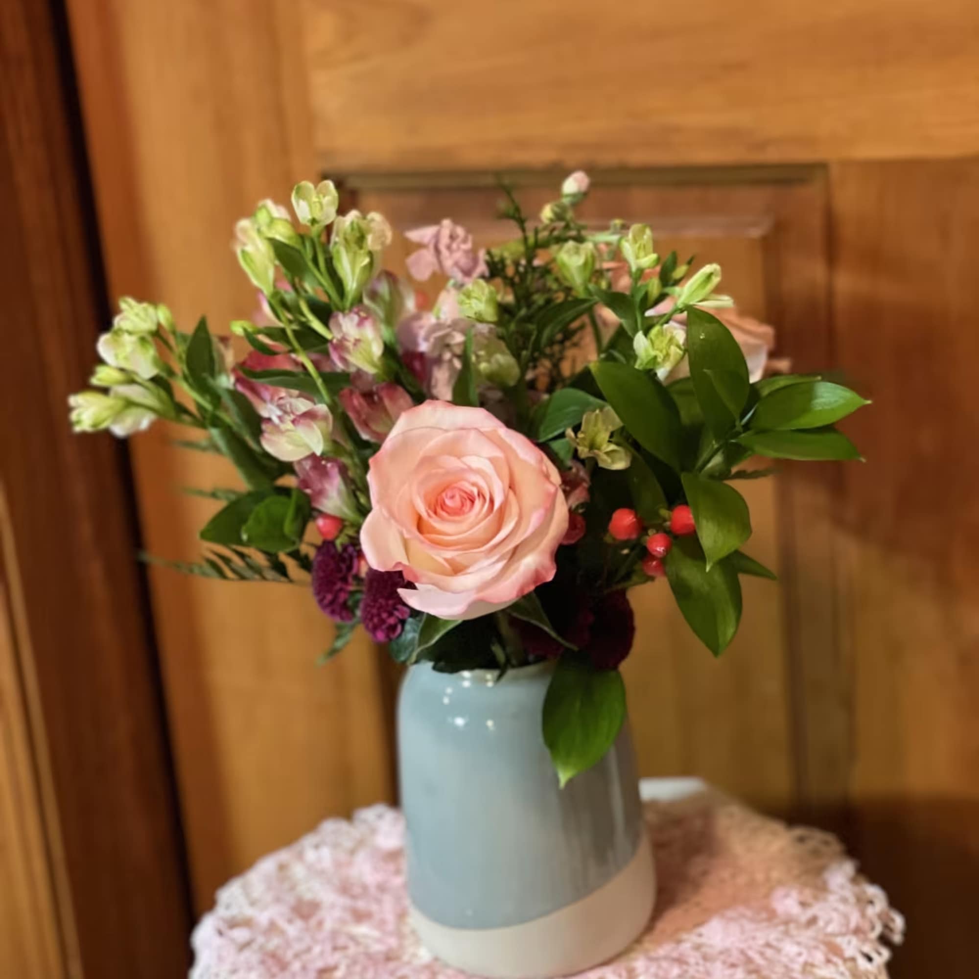 Pink rose bouquet in a blue vase with mixed blooms