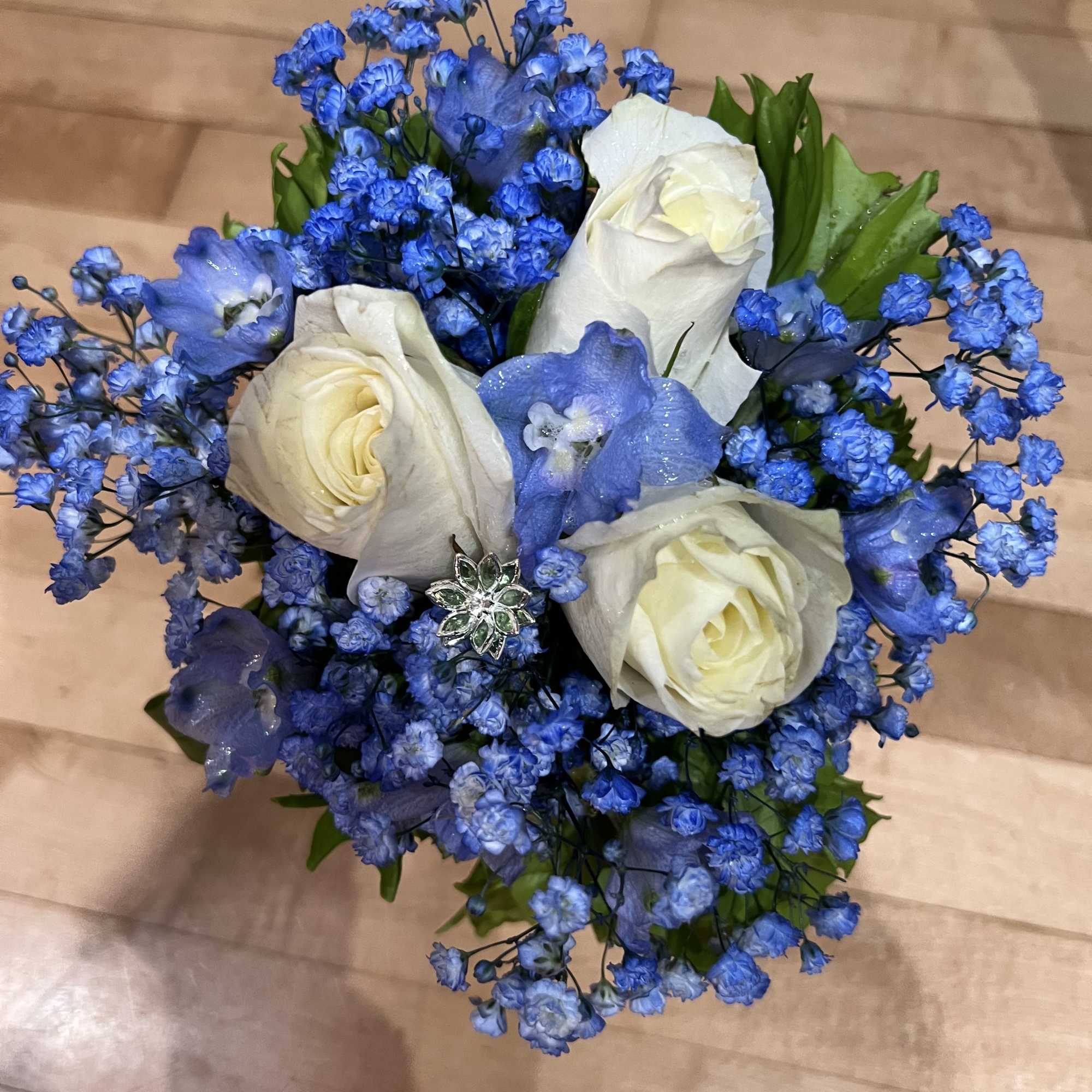 Blue and white rose bouquet with small blue filler flowers