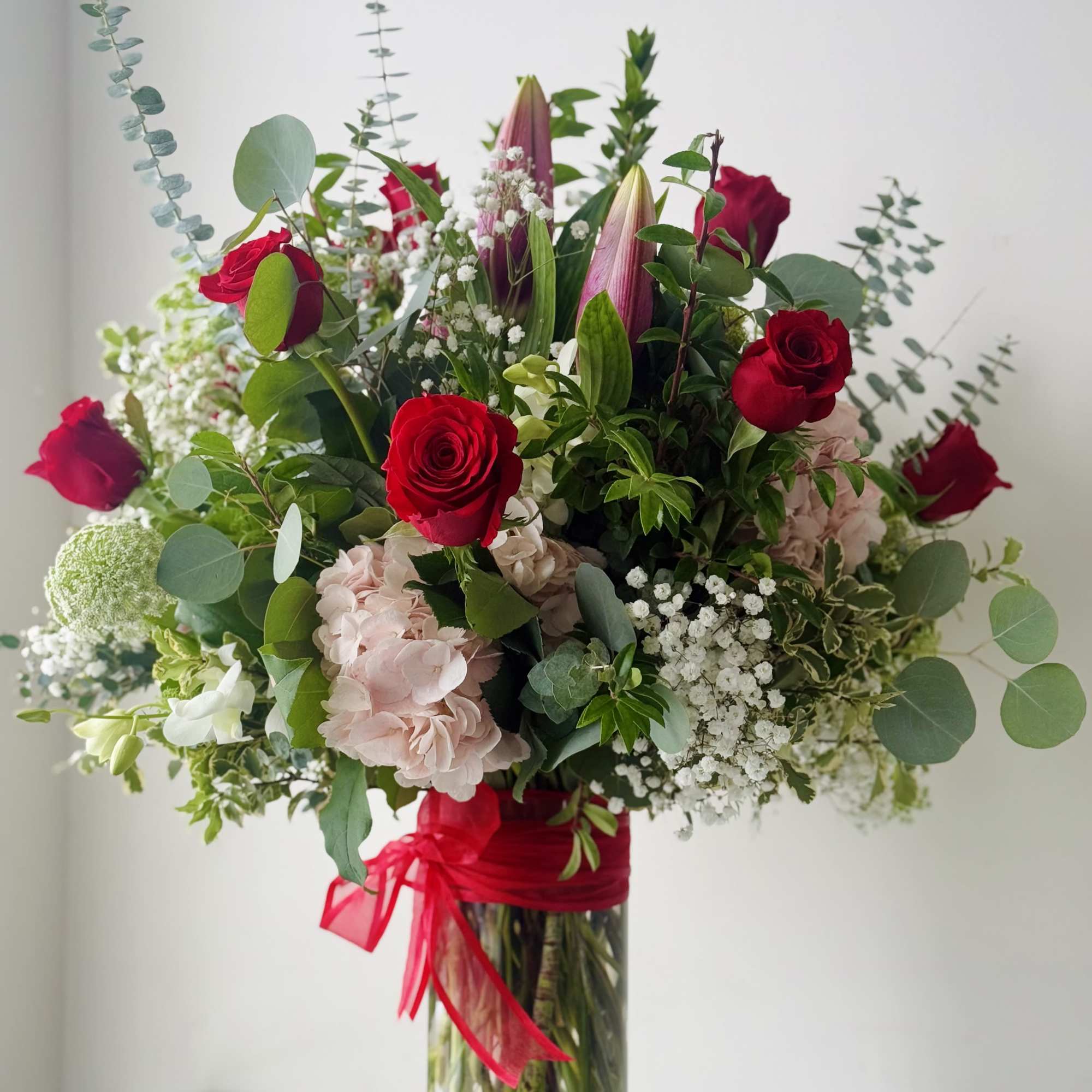 Bouquet of red roses and pink hydrangeas in a glass vase