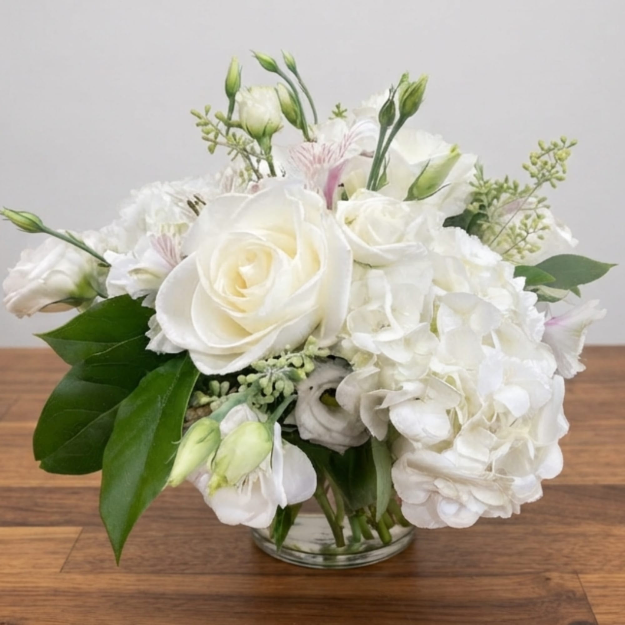 White rose and hydrangea bouquet in a clear glass vase