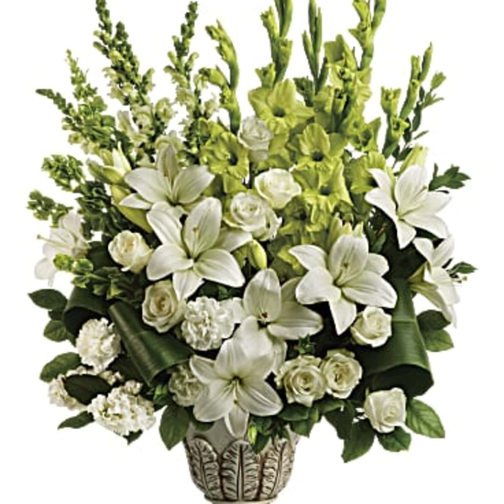 Tall white and green arrangement of lilies, roses, and carnations in an ornate pedestal vase