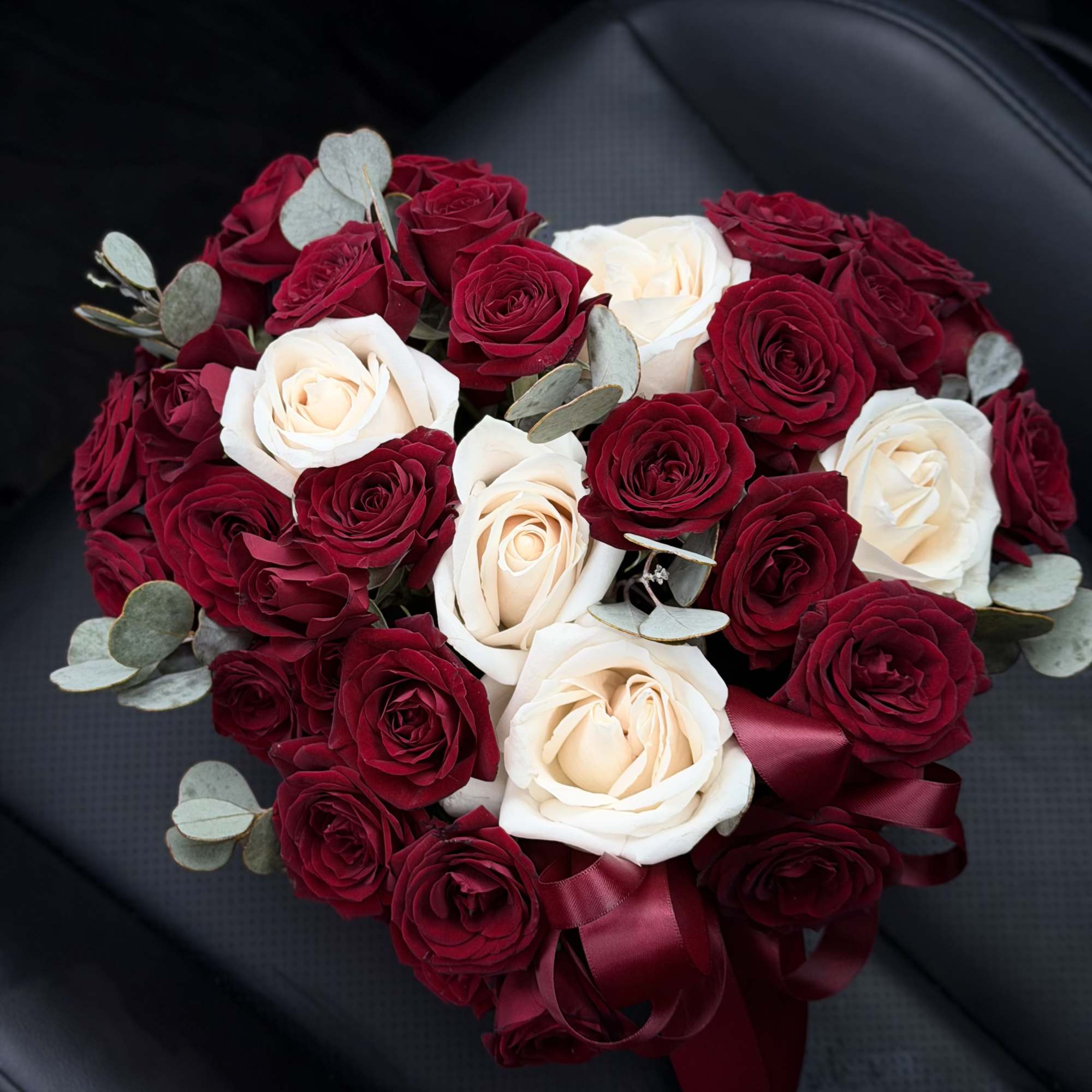 Heart-shaped bouquet of red and white roses with ribbon
