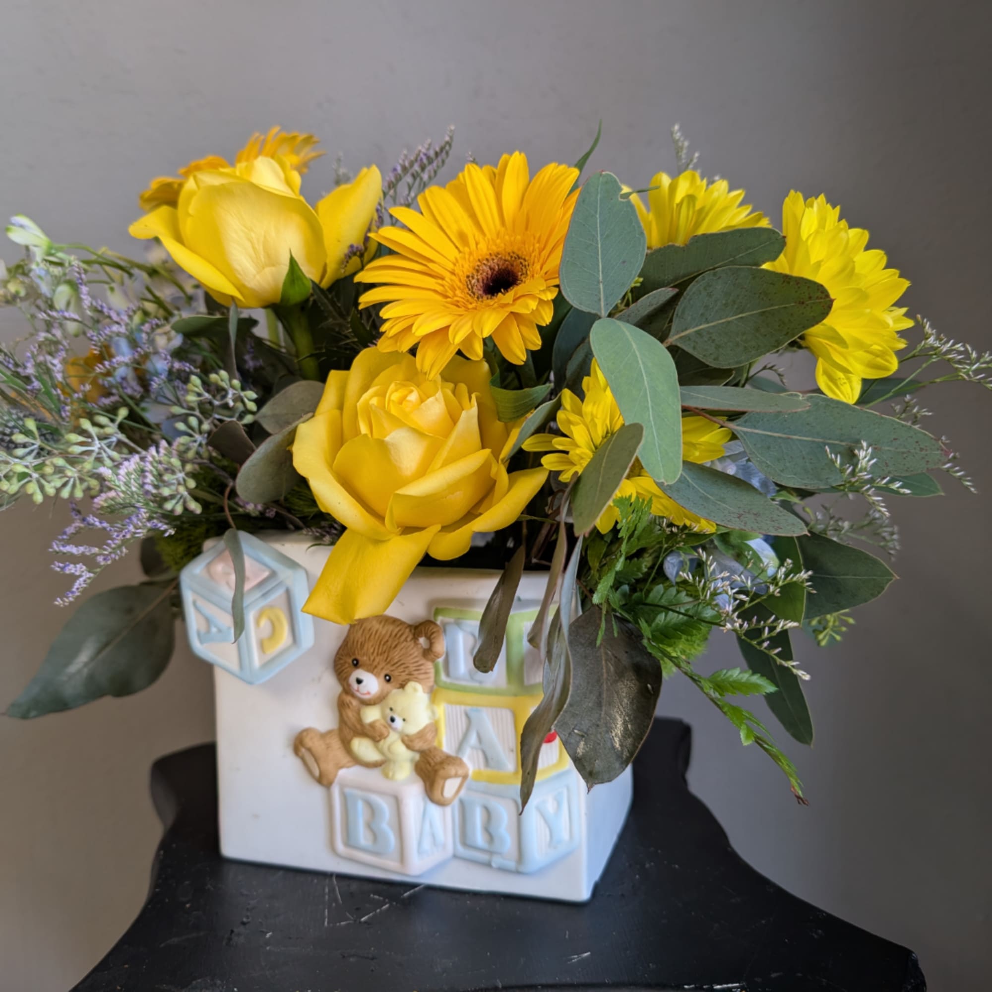 Yellow roses and daisies in a baby-themed ceramic vase, photo 2 of 3