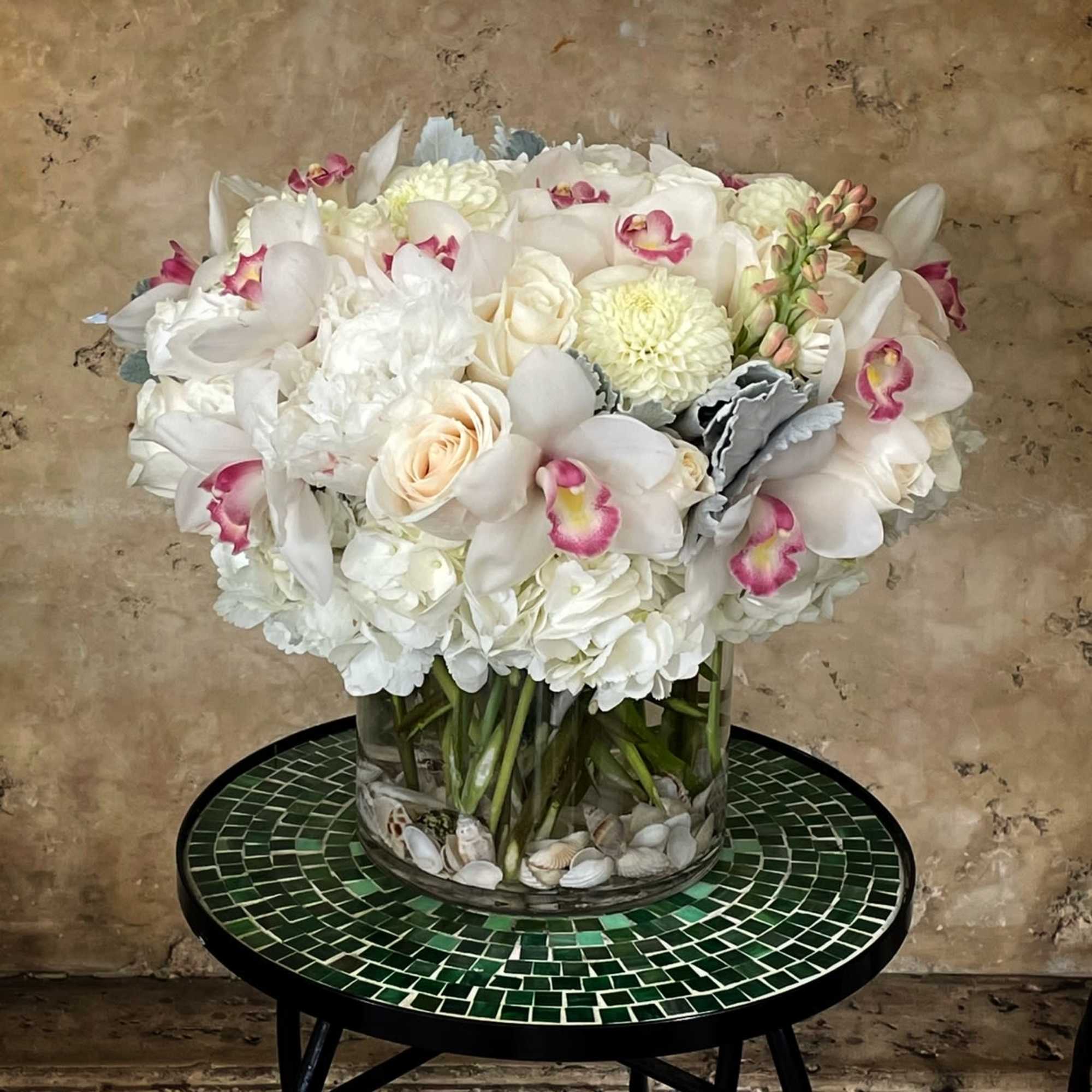 White and blush floral arrangement in a clear glass vase