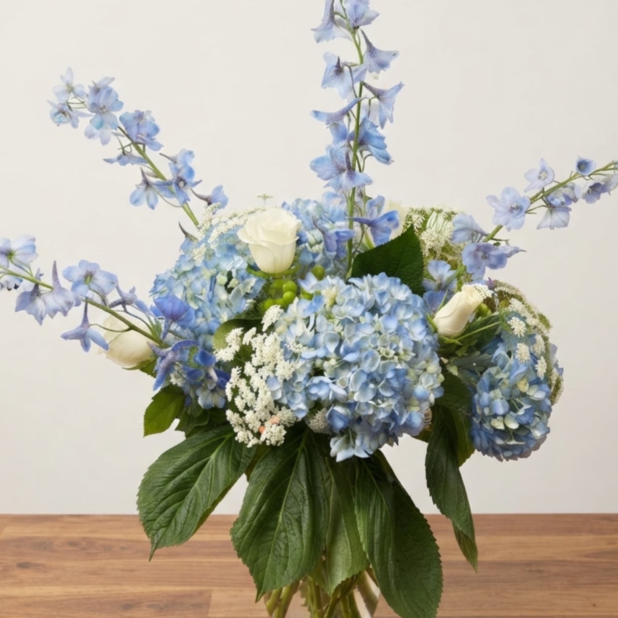 Blue hydrangeas and white roses in a bouquet with tall blue flowers