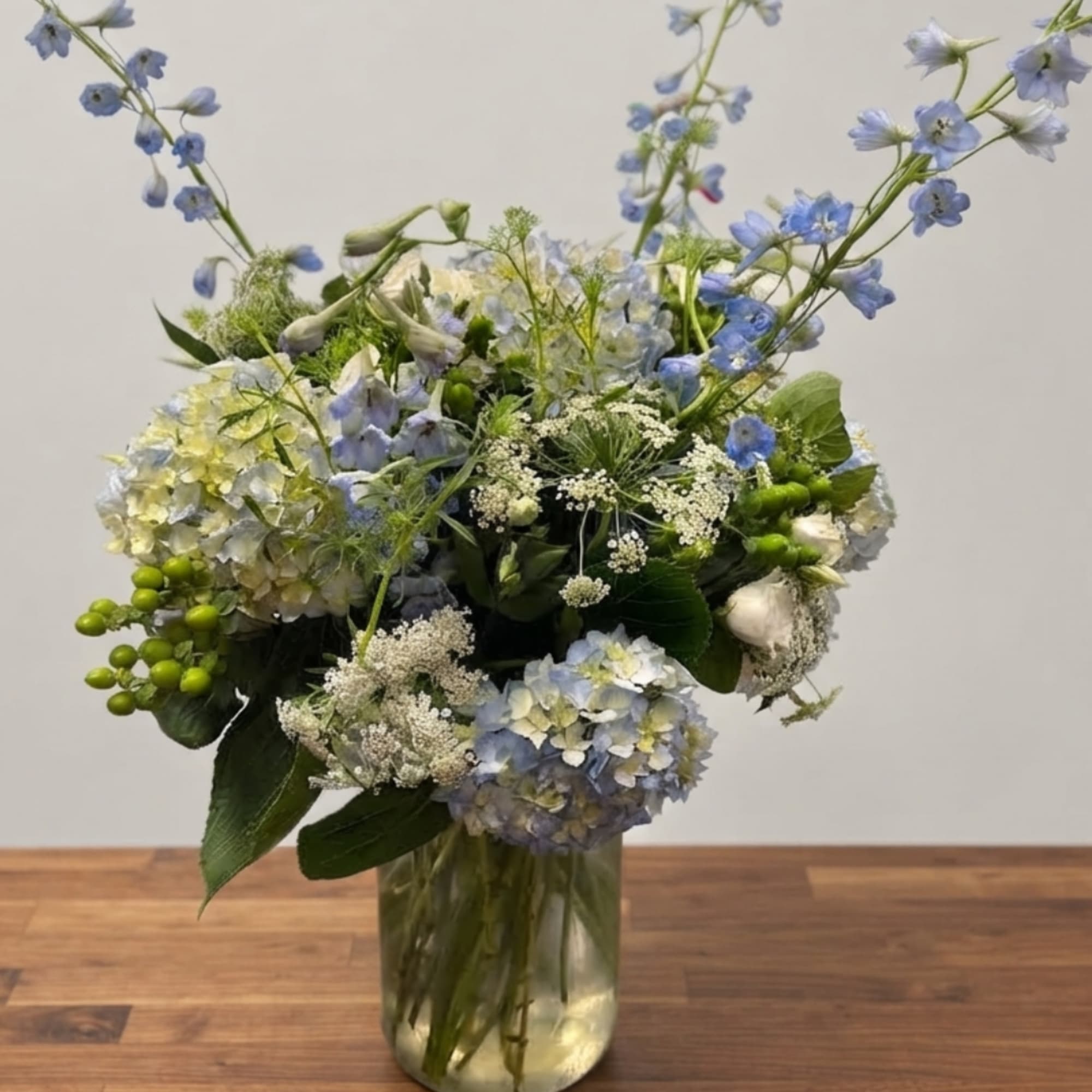 Blue and white floral arrangement in a glass vase
