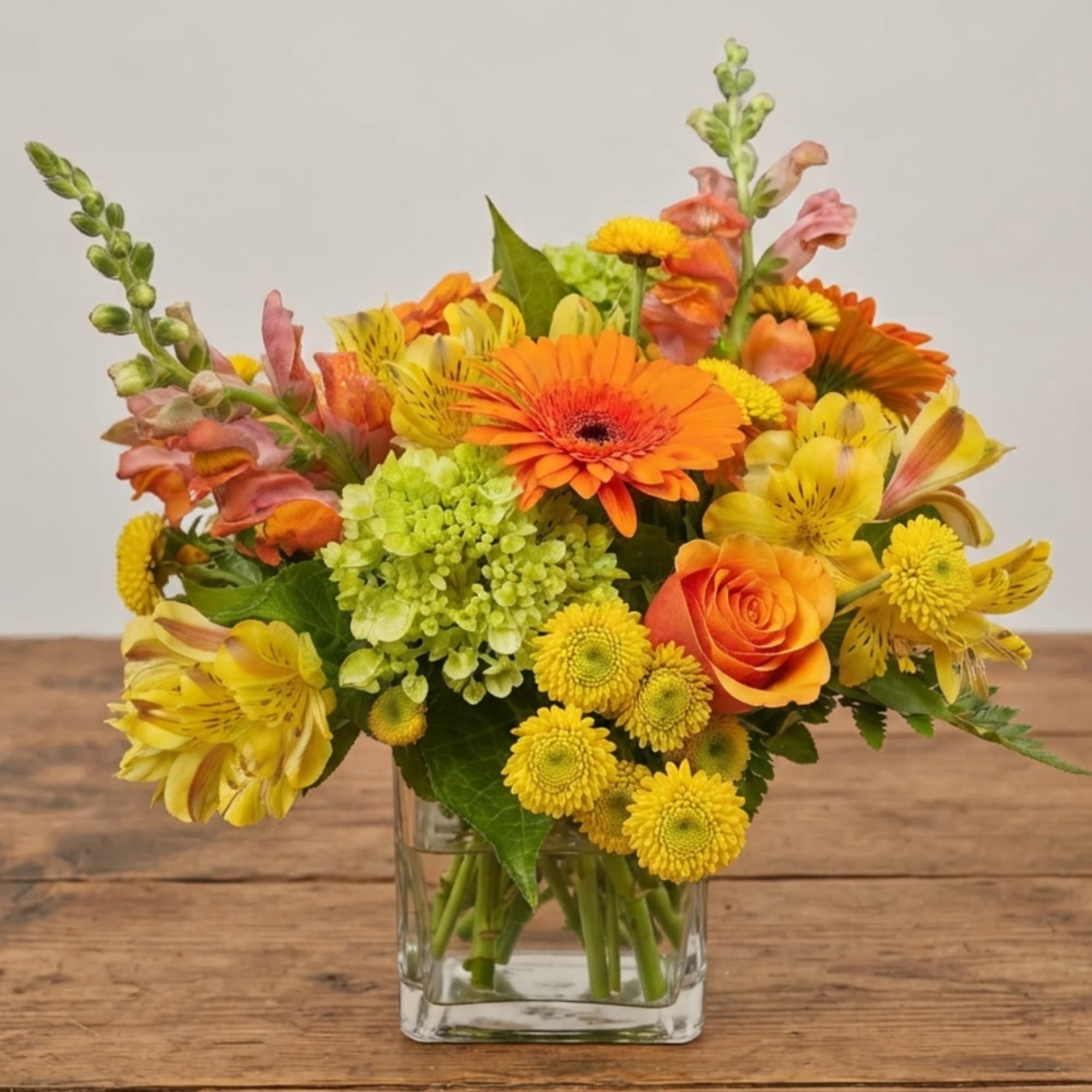 Orange and yellow mixed bouquet in a clear glass vase