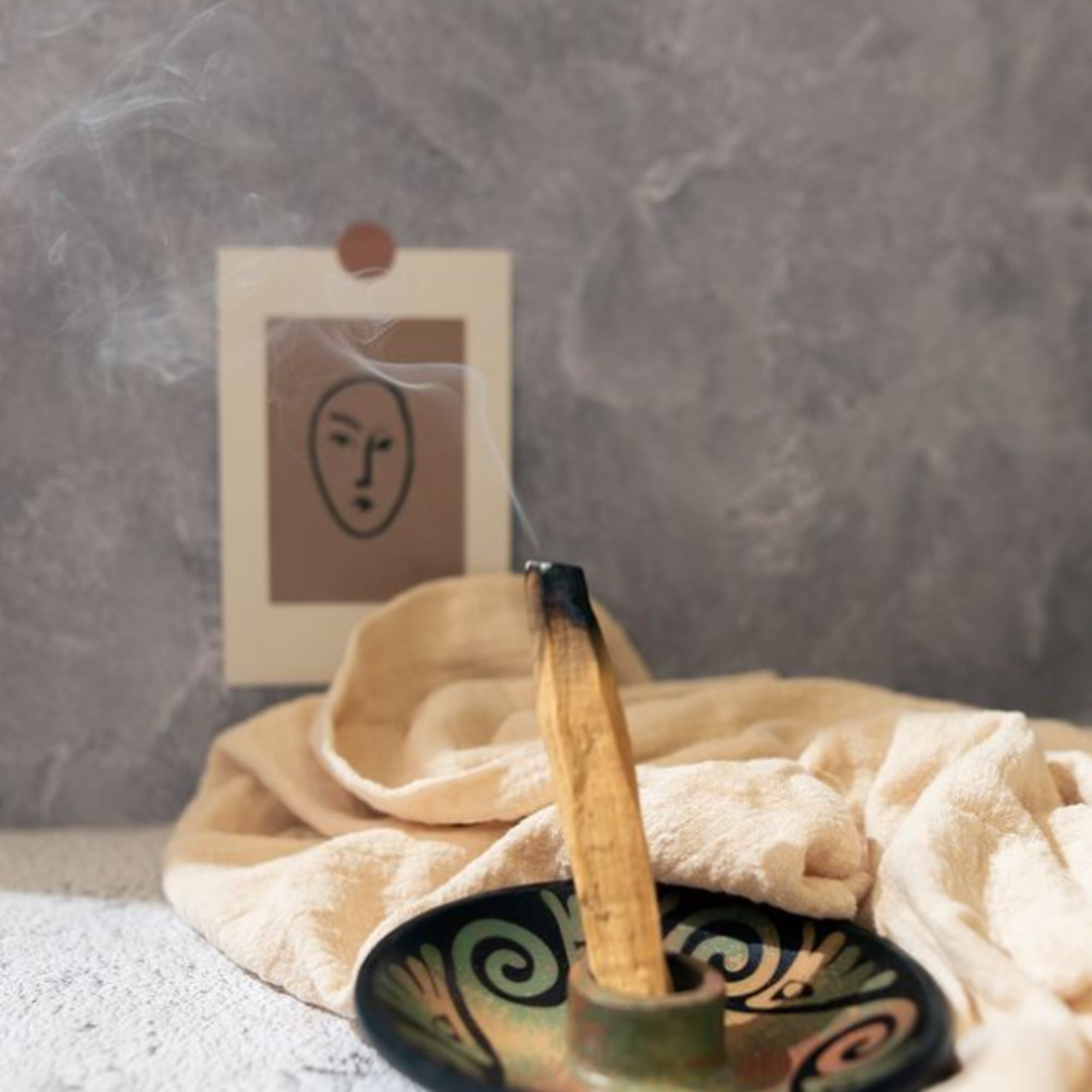 Burning incense in a decorative bowl with a small card behind it