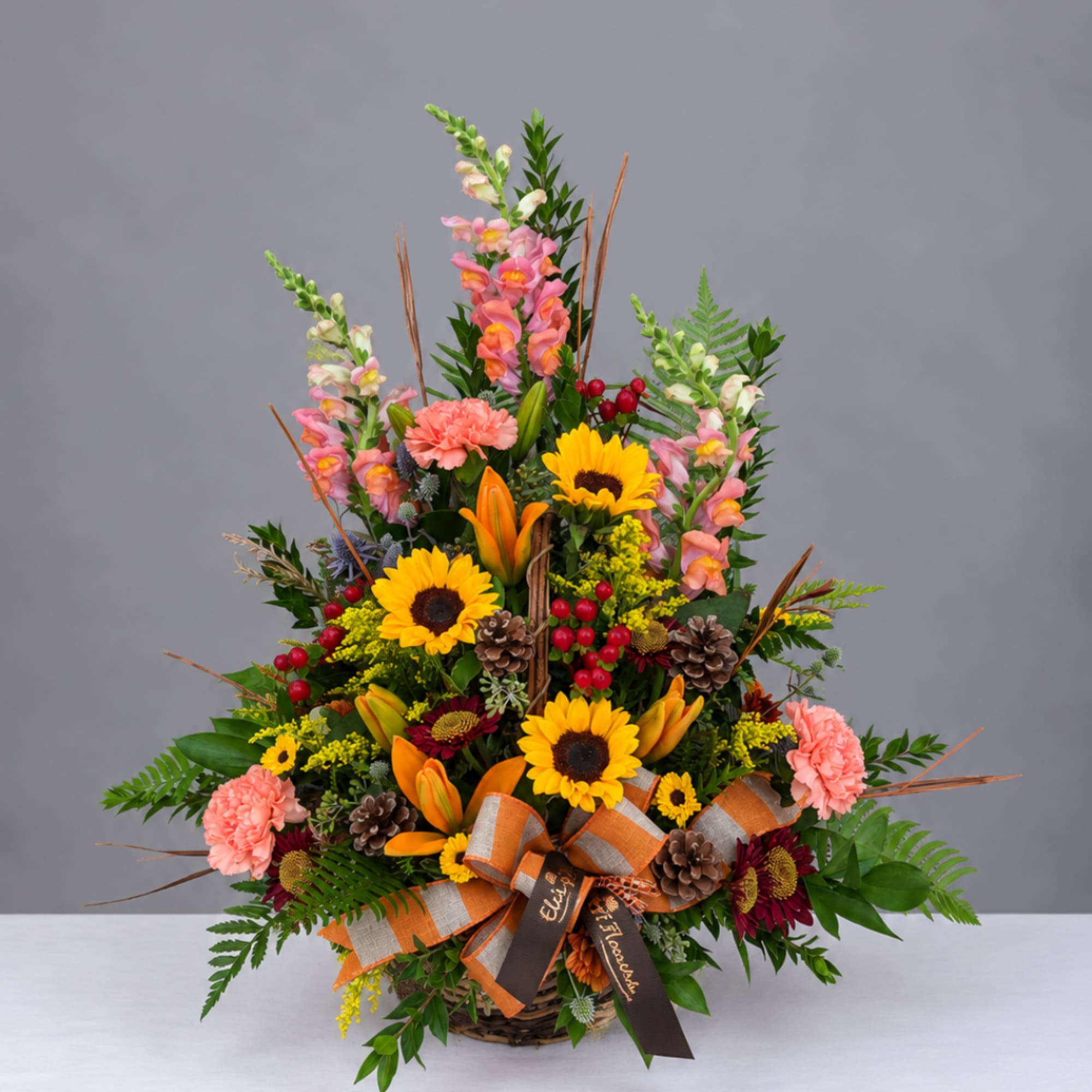 Basket arrangement with sunflowers, lilies, carnations, and snapdragons