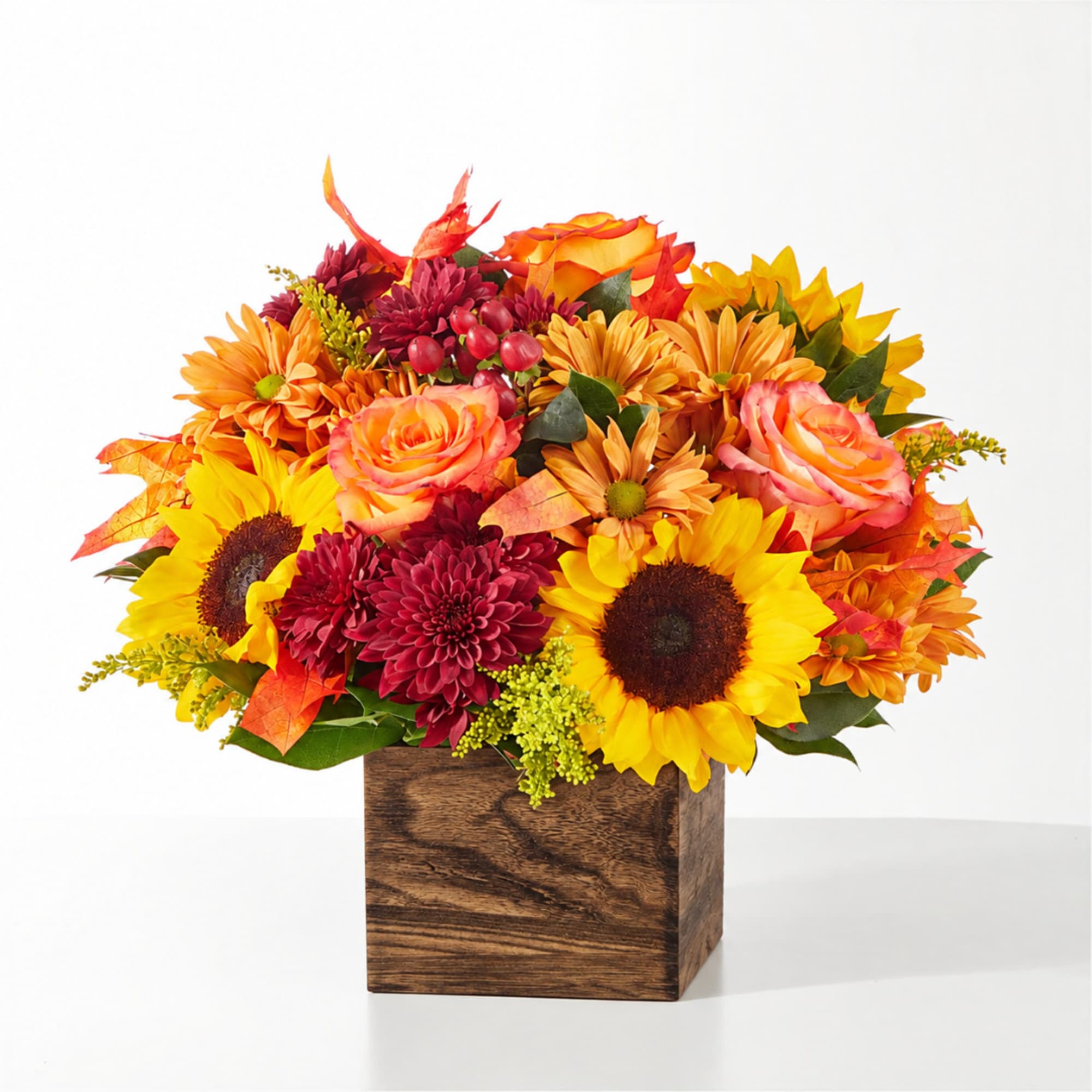 Autumn bouquet with sunflowers, roses, and mums in a wooden cube vase