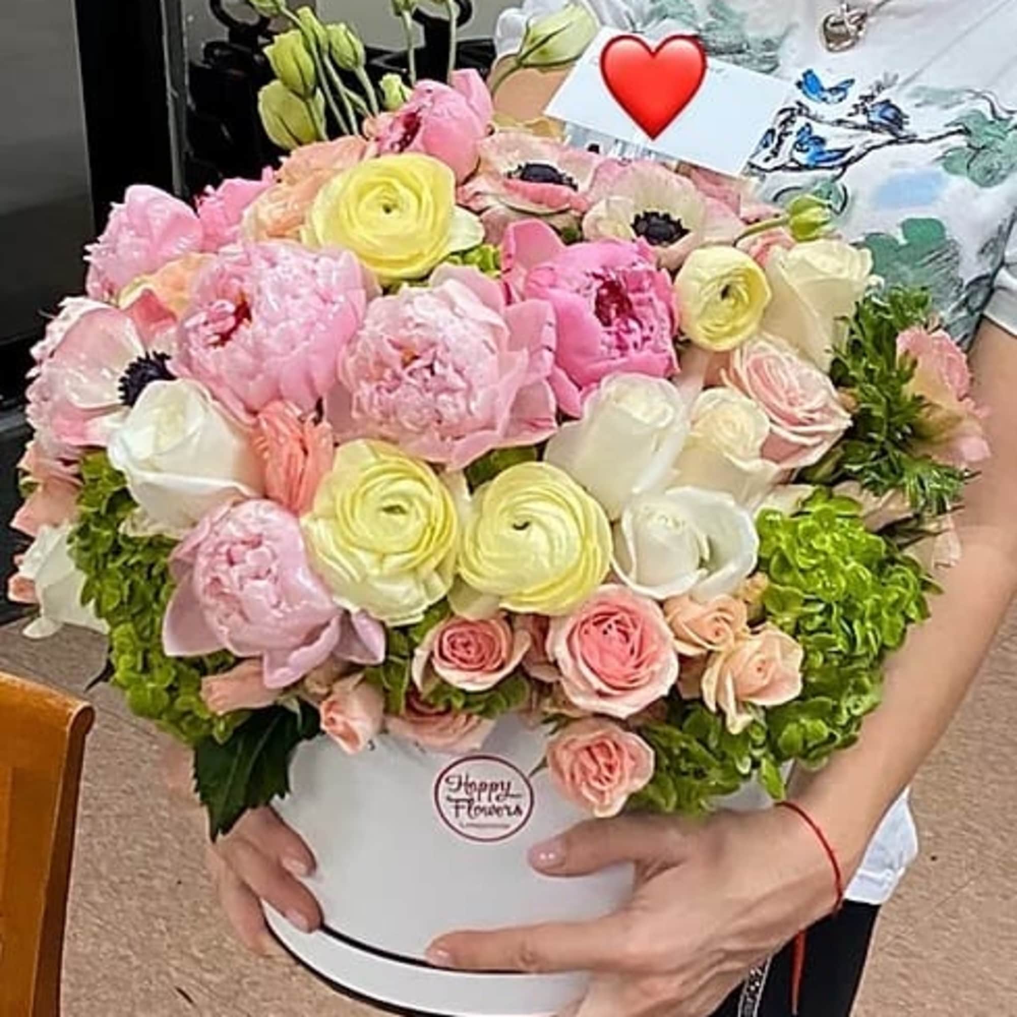 Large pastel bouquet of pink, white, and yellow flowers in a white box