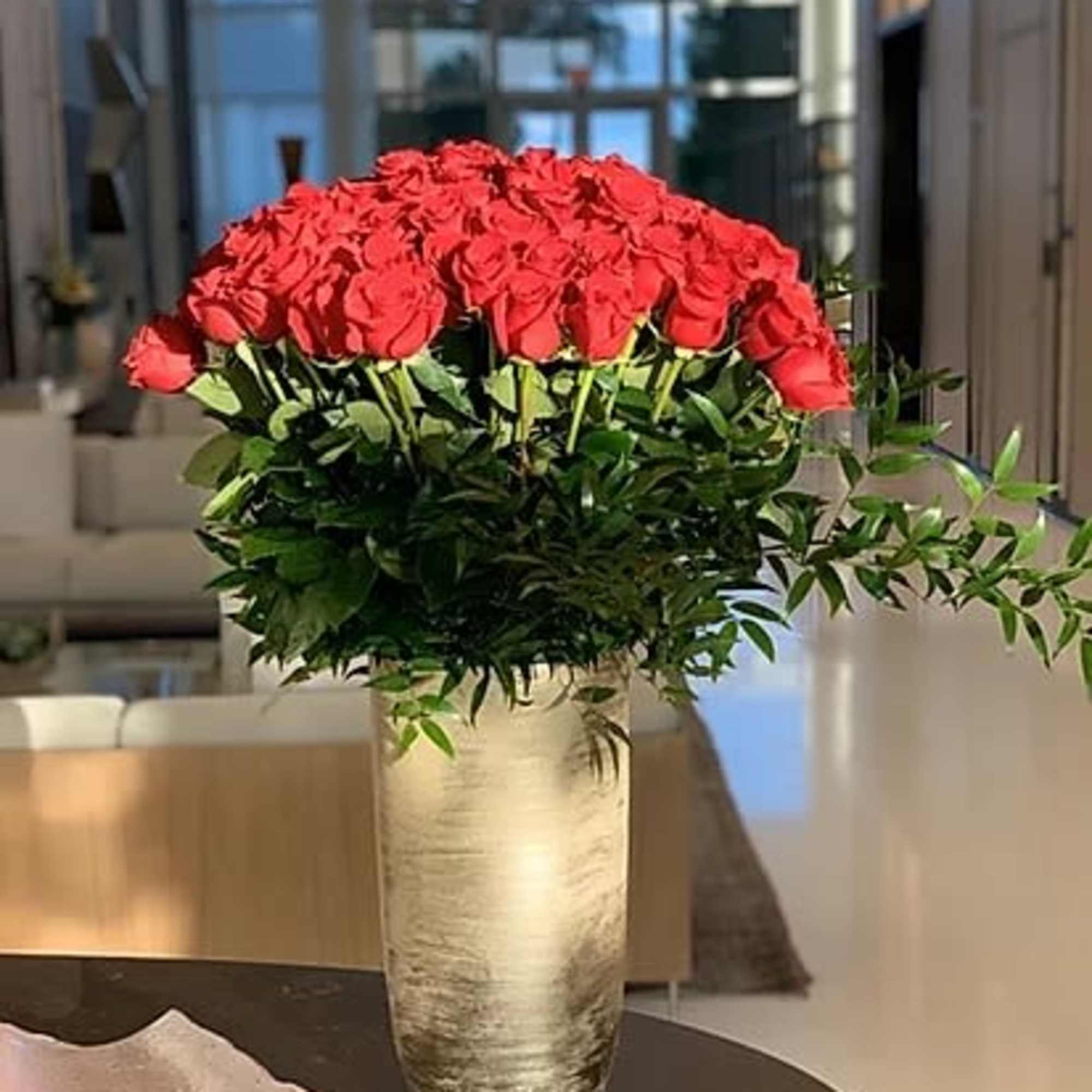 Large bouquet of red roses in a tall metallic vase