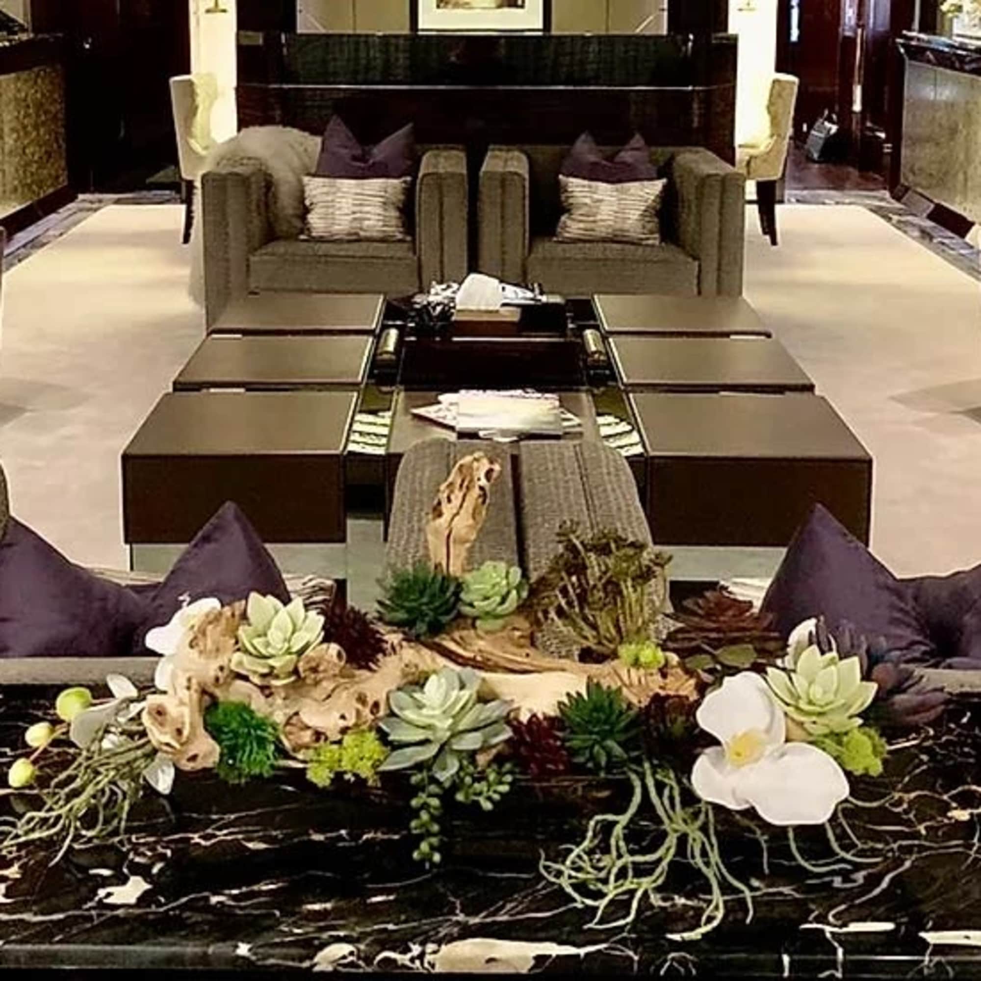 Succulent centerpiece with white orchids on a marble table