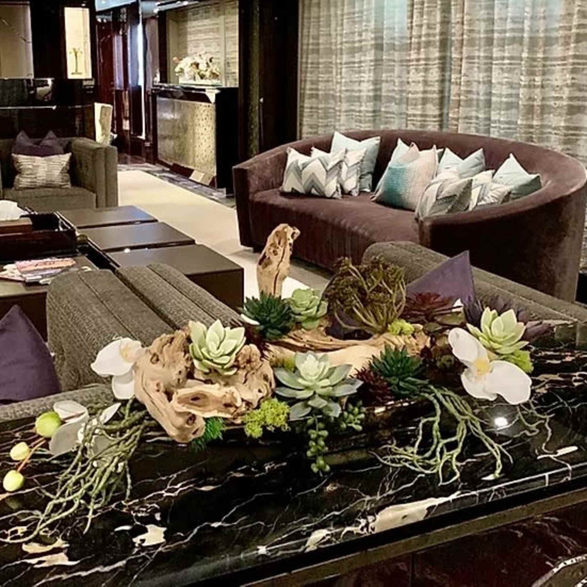Succulent arrangement with white orchids on a black marble table
