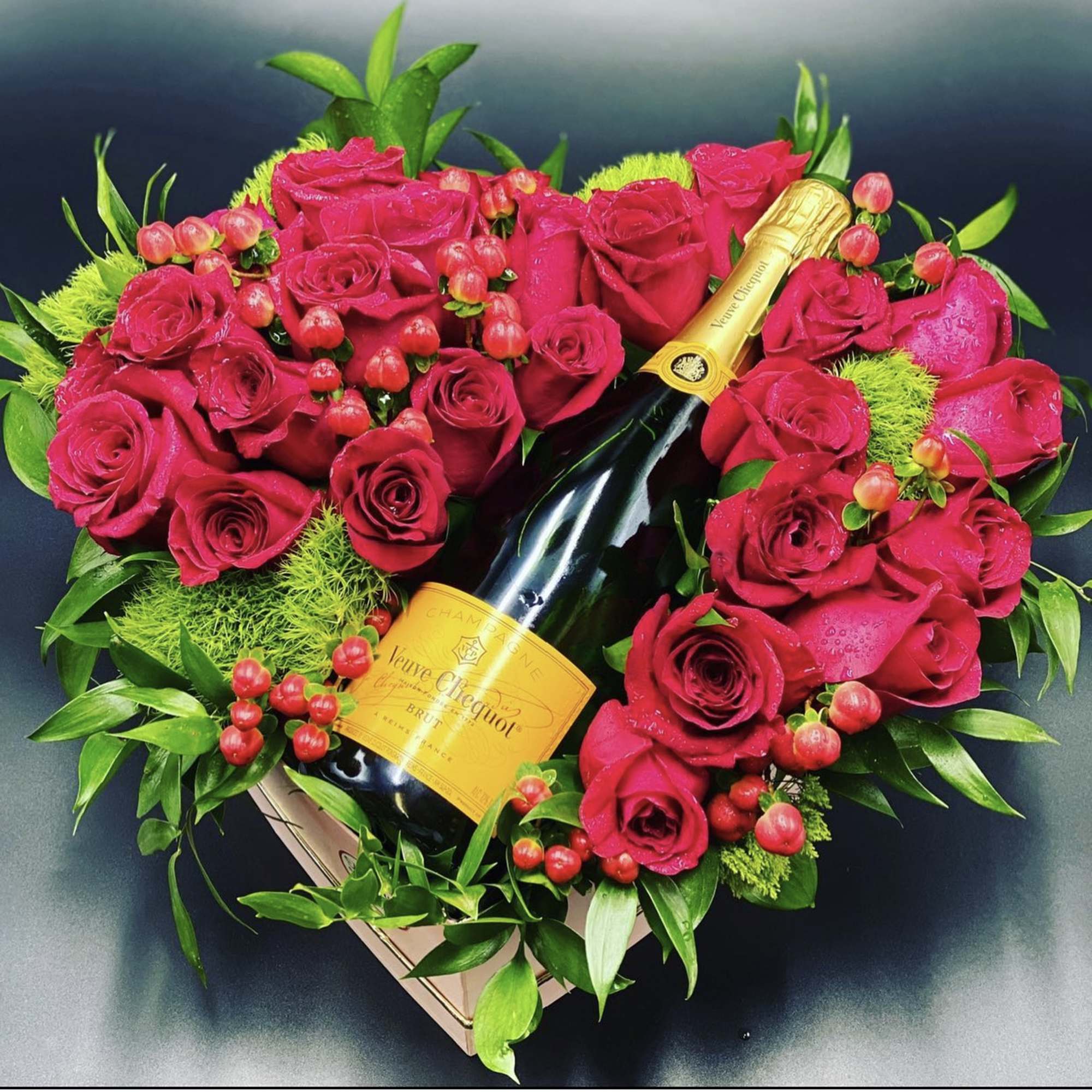 Heart-shaped rose arrangement with a champagne bottle in the center