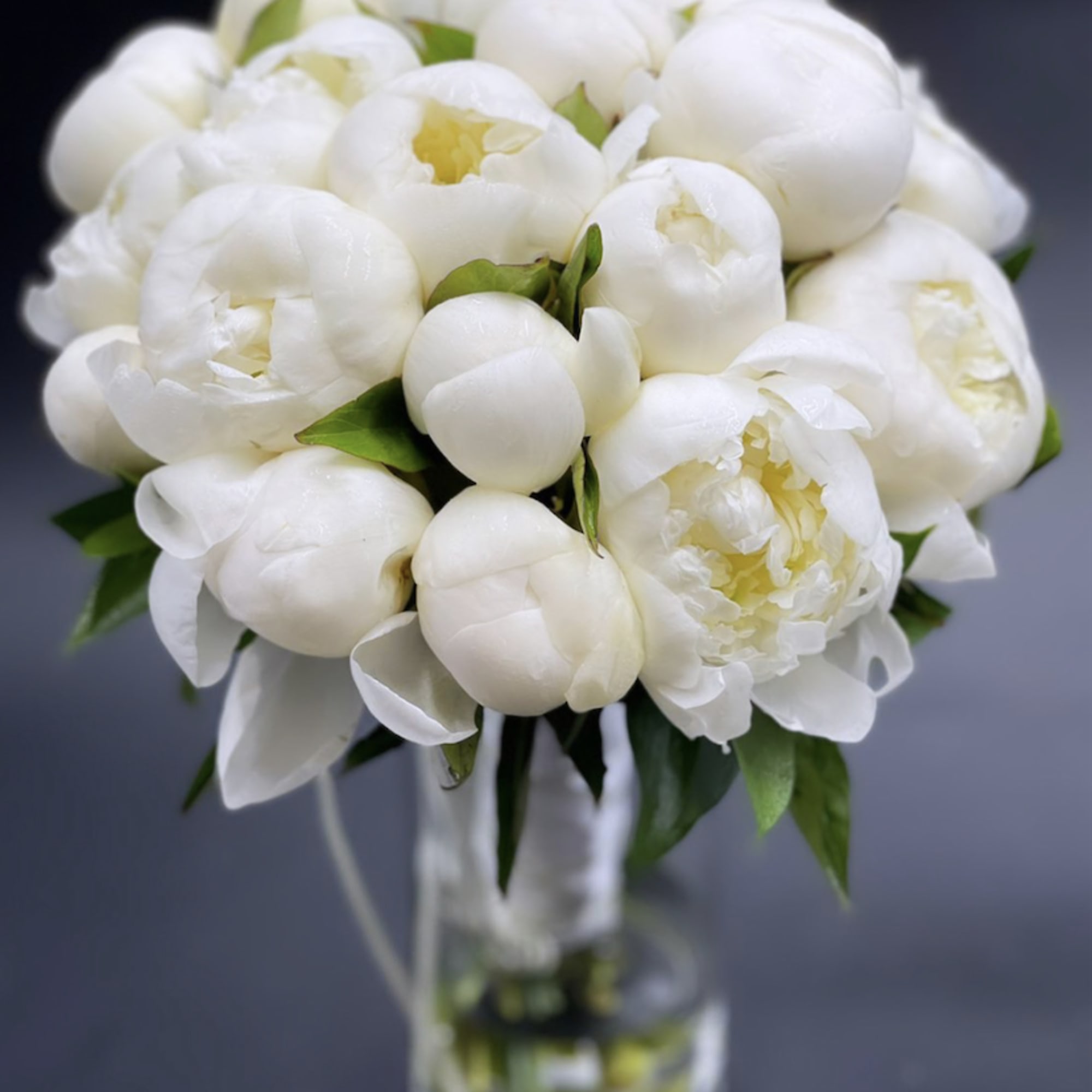 White peony bouquet in a clear glass vase