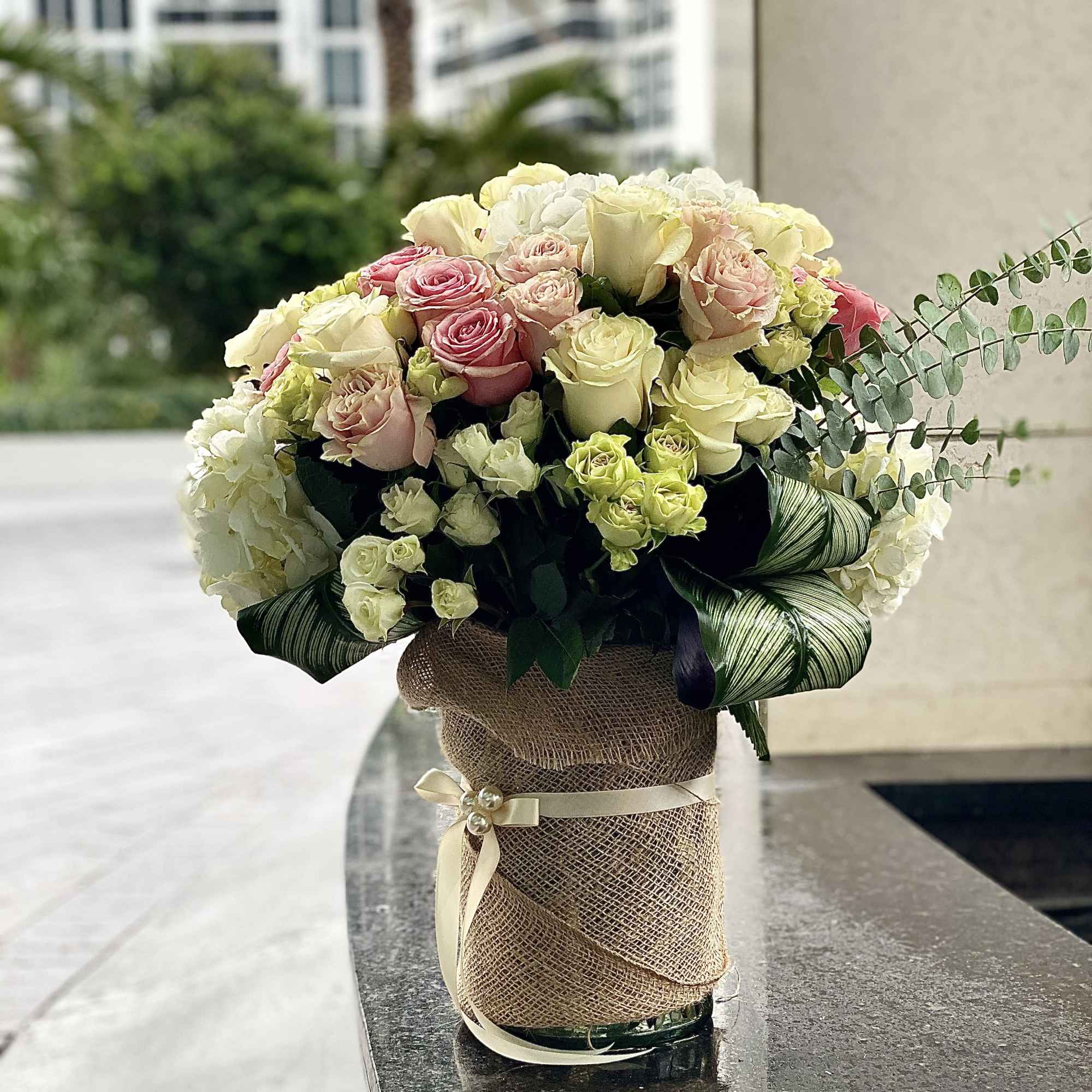 Bouquet of pink and cream roses in a burlap-wrapped vase, photo 2 of 2