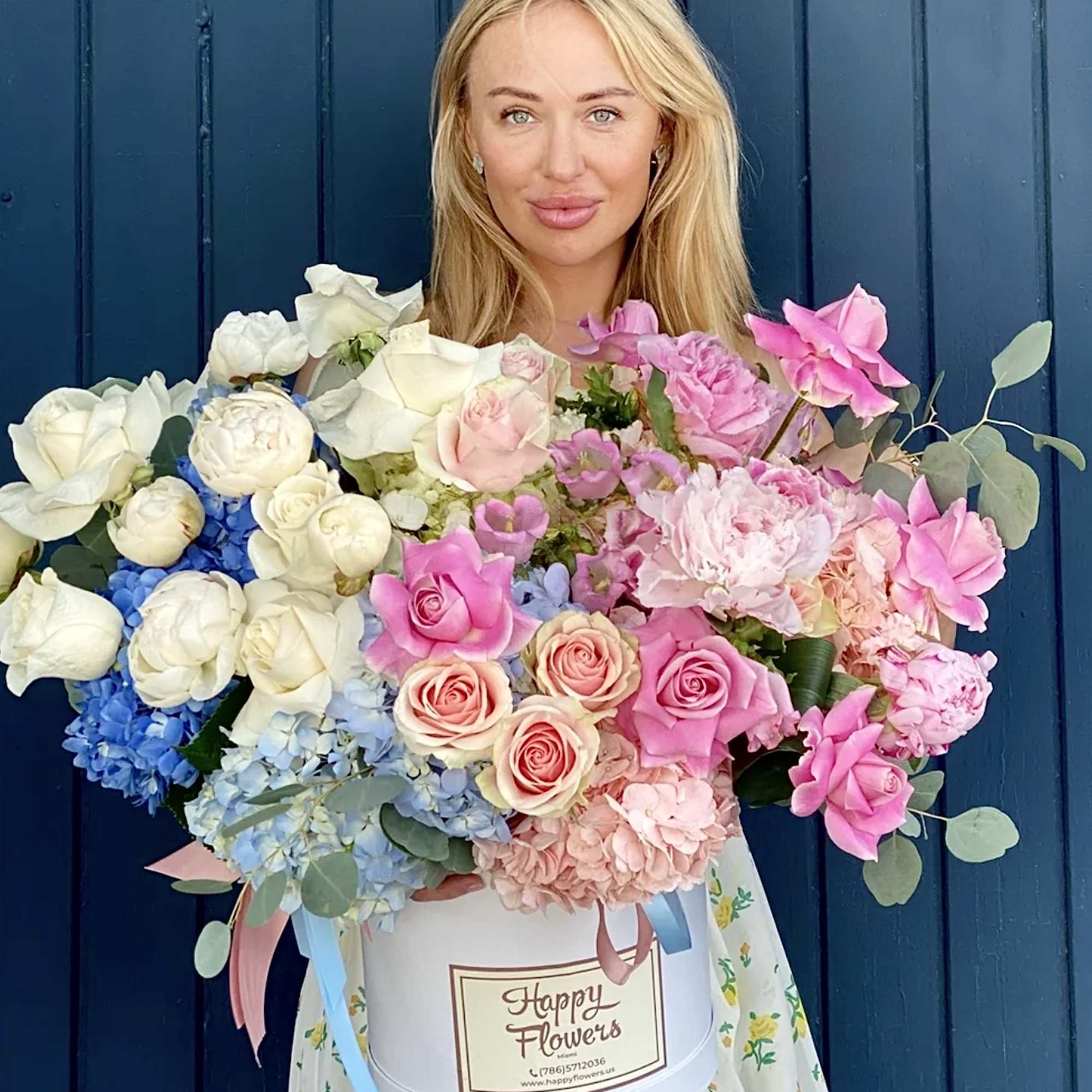 Woman holding a large mixed bouquet in a white hatbox