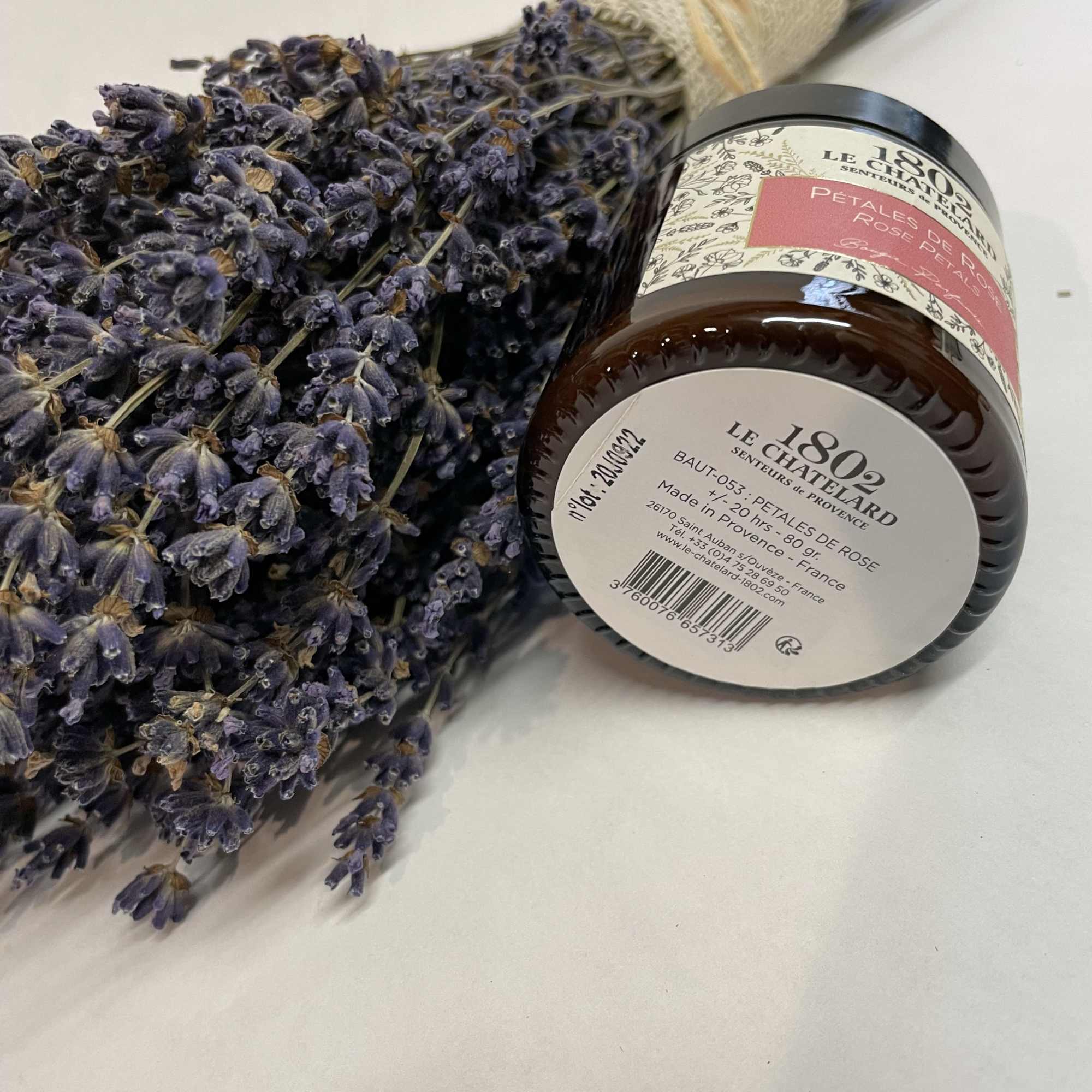 Bundle of dried lavender beside a jar of rose petal scent