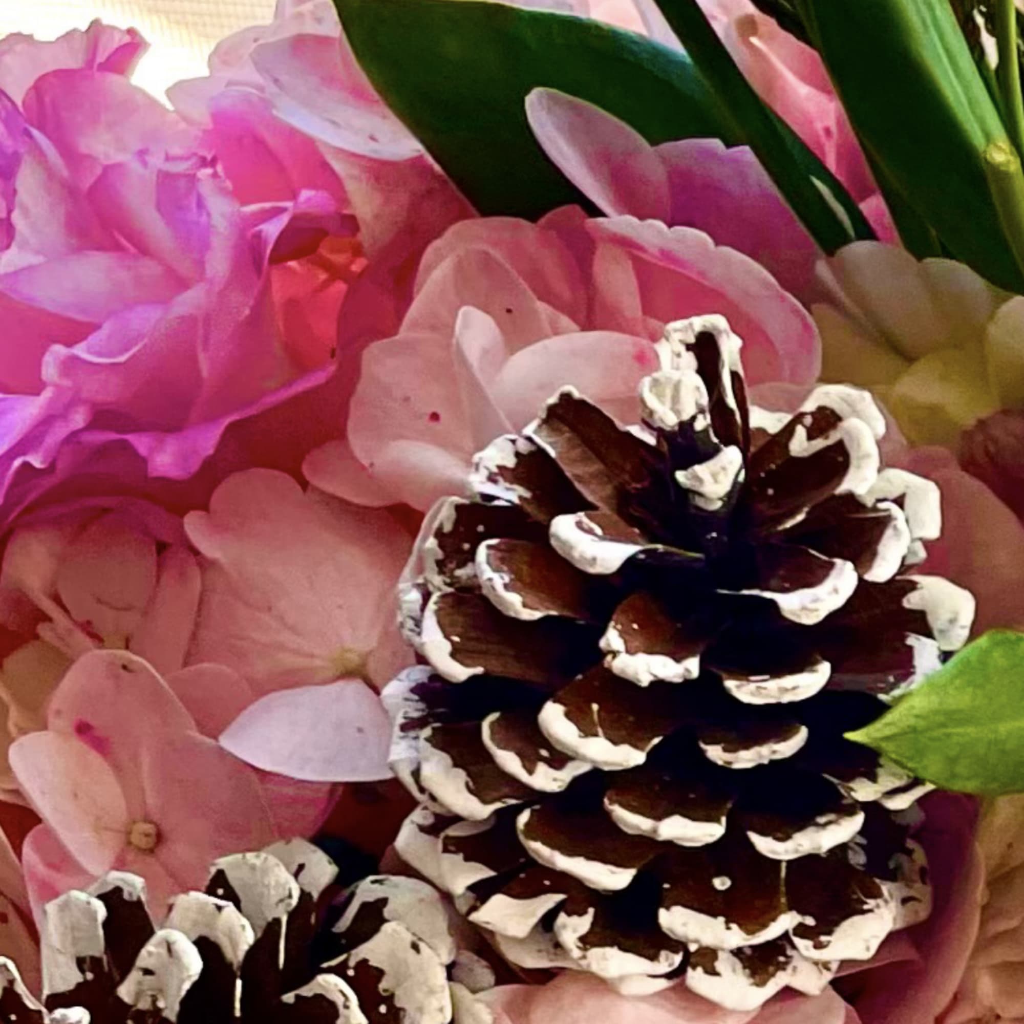 Pink hydrangeas with pinecones and green foliage