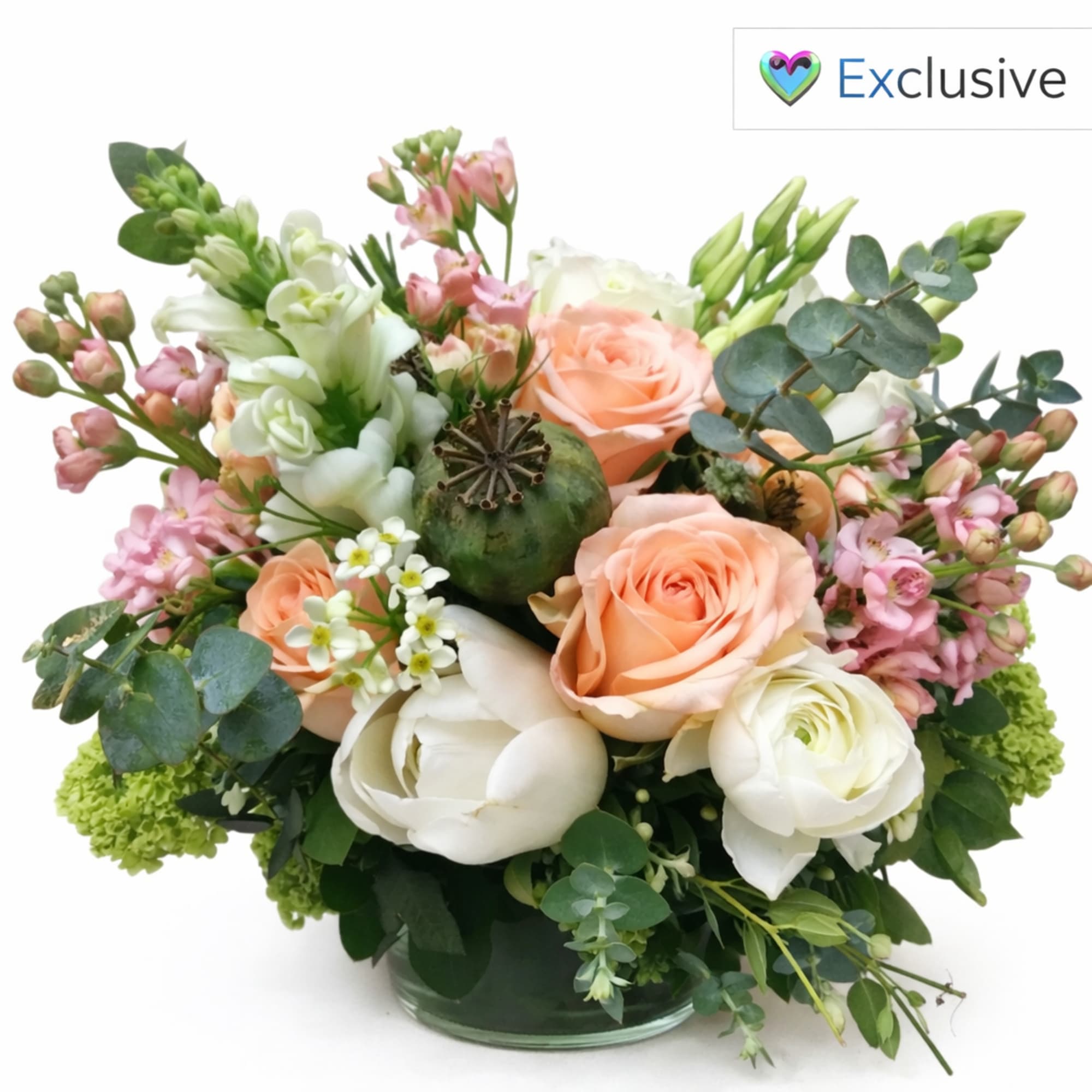 Peach and white roses in a glass vase with pink filler flowers