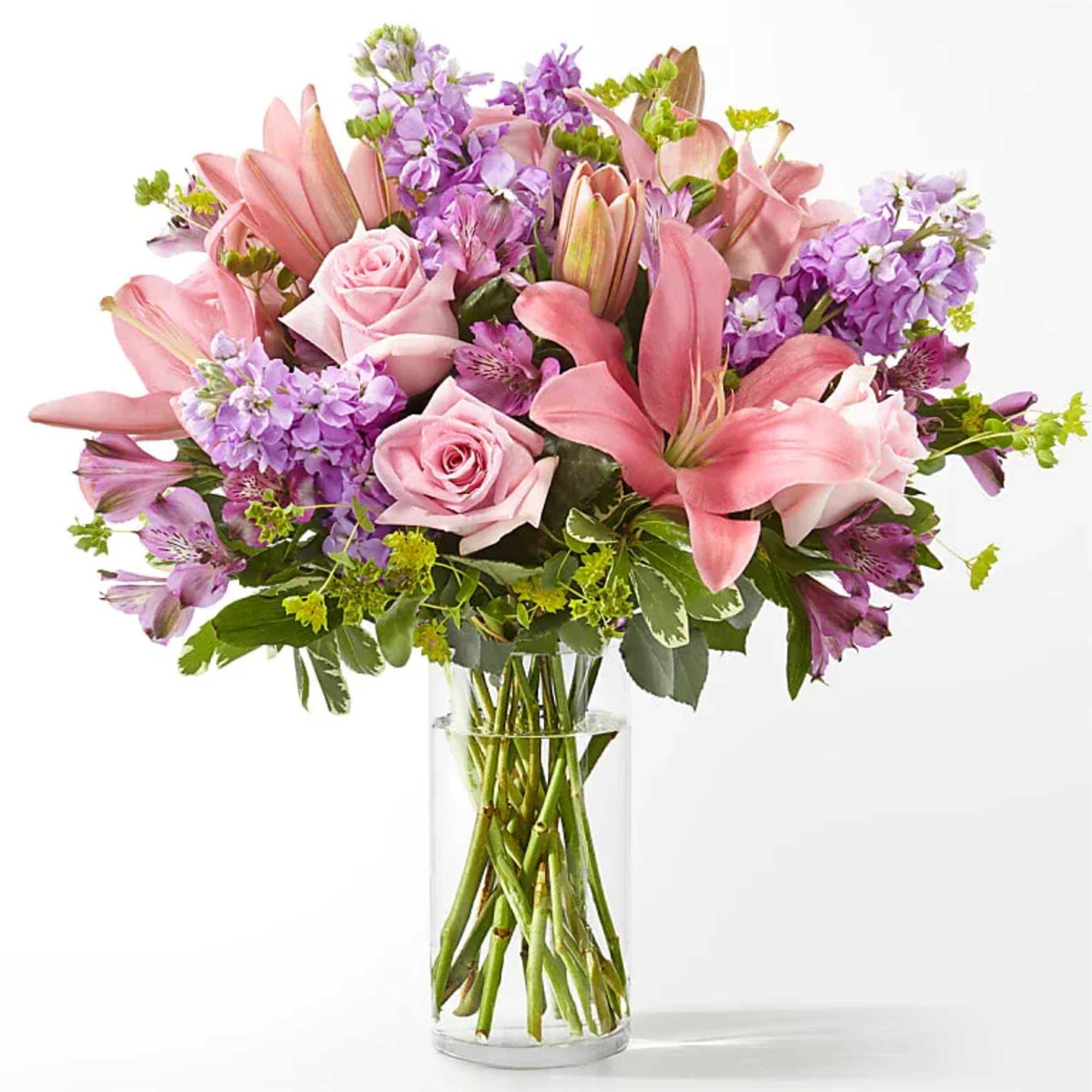 Pink roses and lilies with purple flowers in a clear glass vase