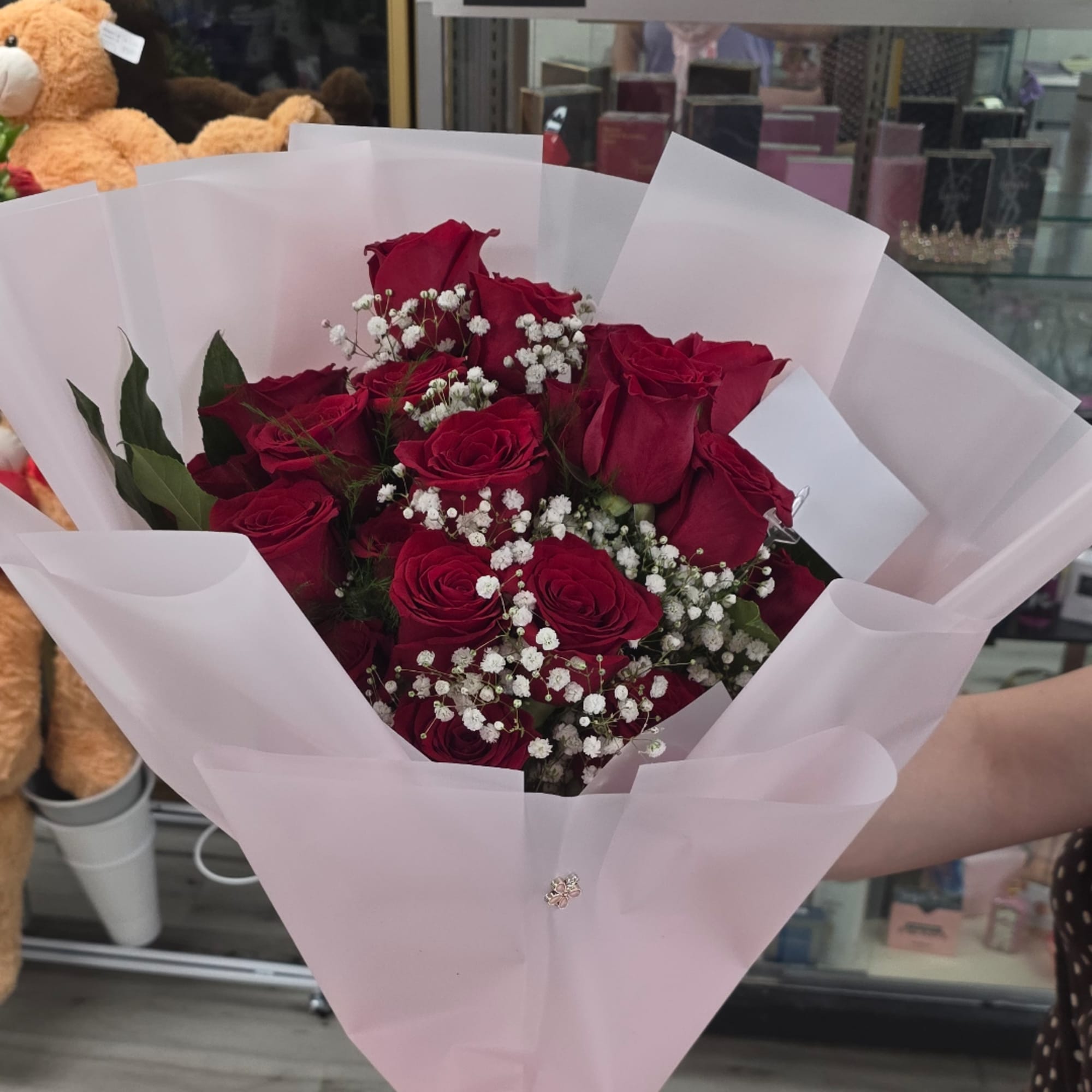 Bouquet of red roses with white baby's breath in pale pink wrapping