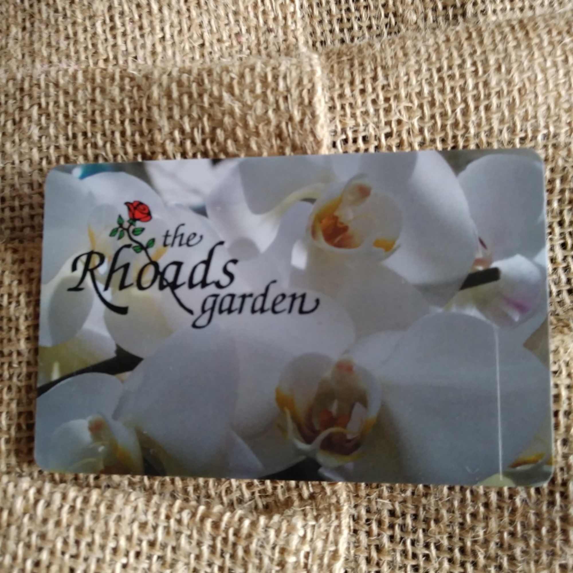 A floral gift card with white orchids and the text "the Rhoads garden"