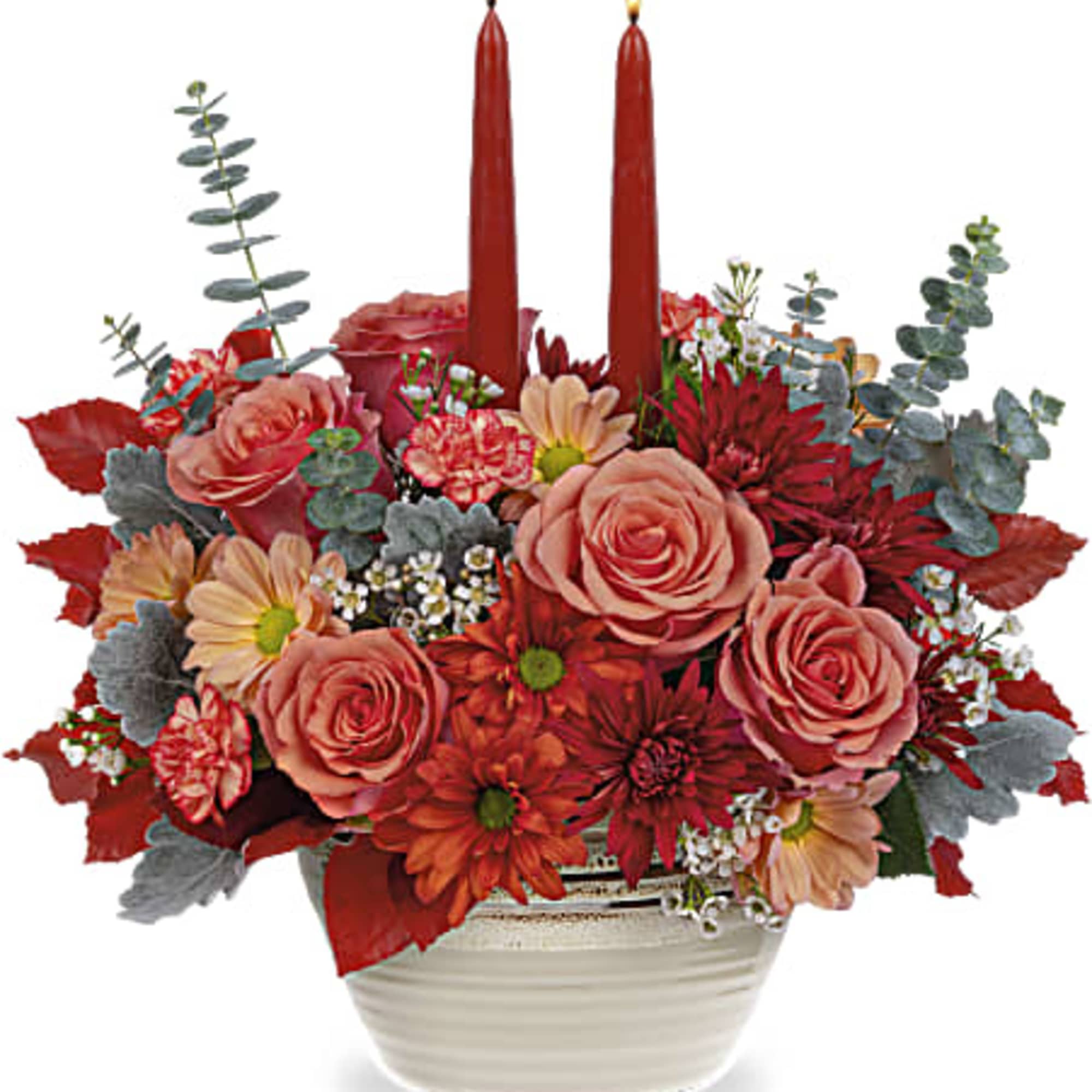 Red floral centerpiece with two tall candles in a white bowl vase
