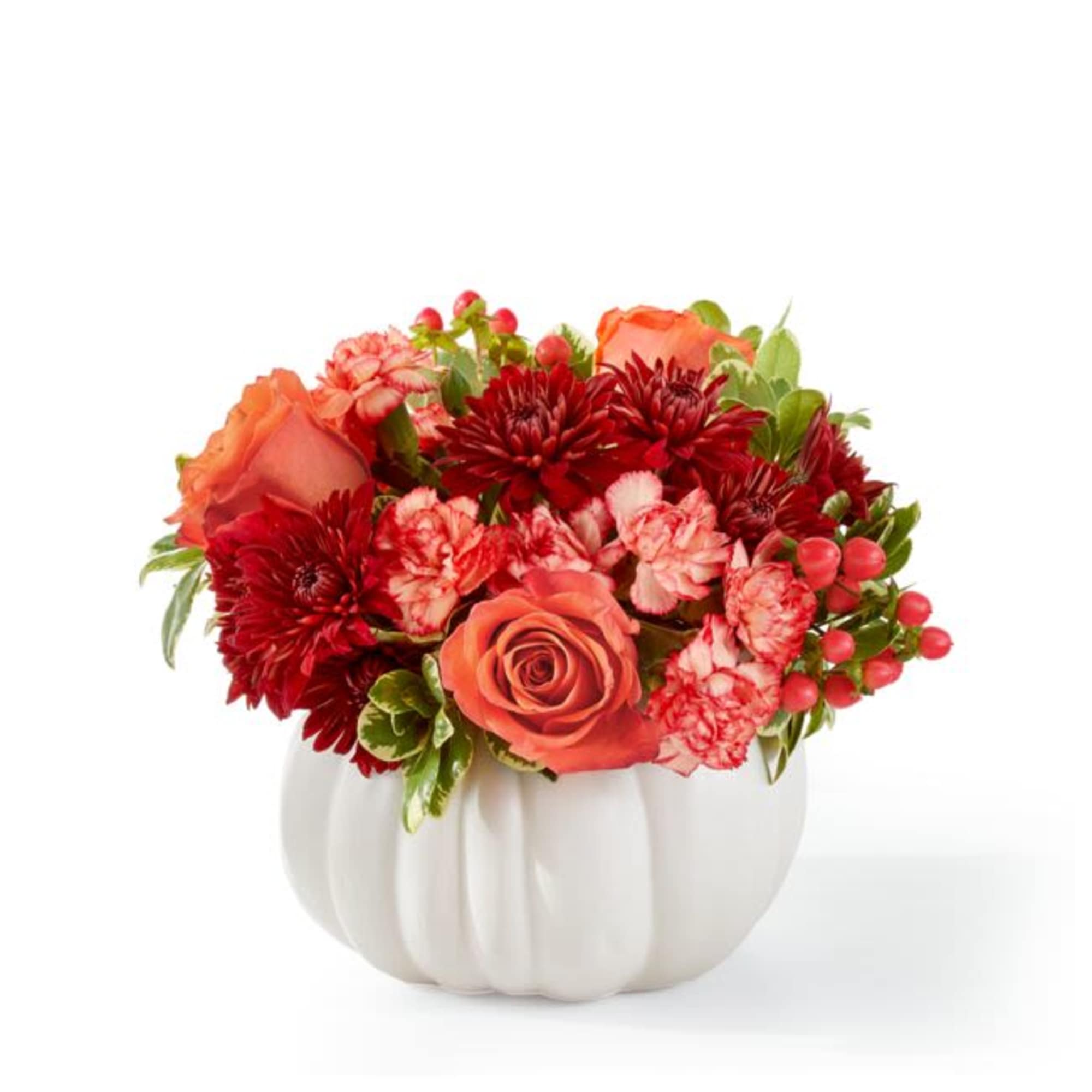 Orange and red flowers arranged in a white pumpkin vase