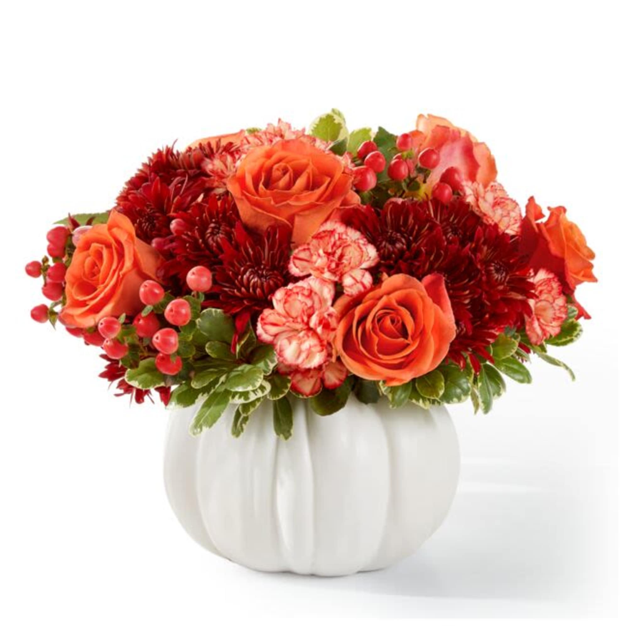 Orange roses and red flowers arranged in a white pumpkin vase