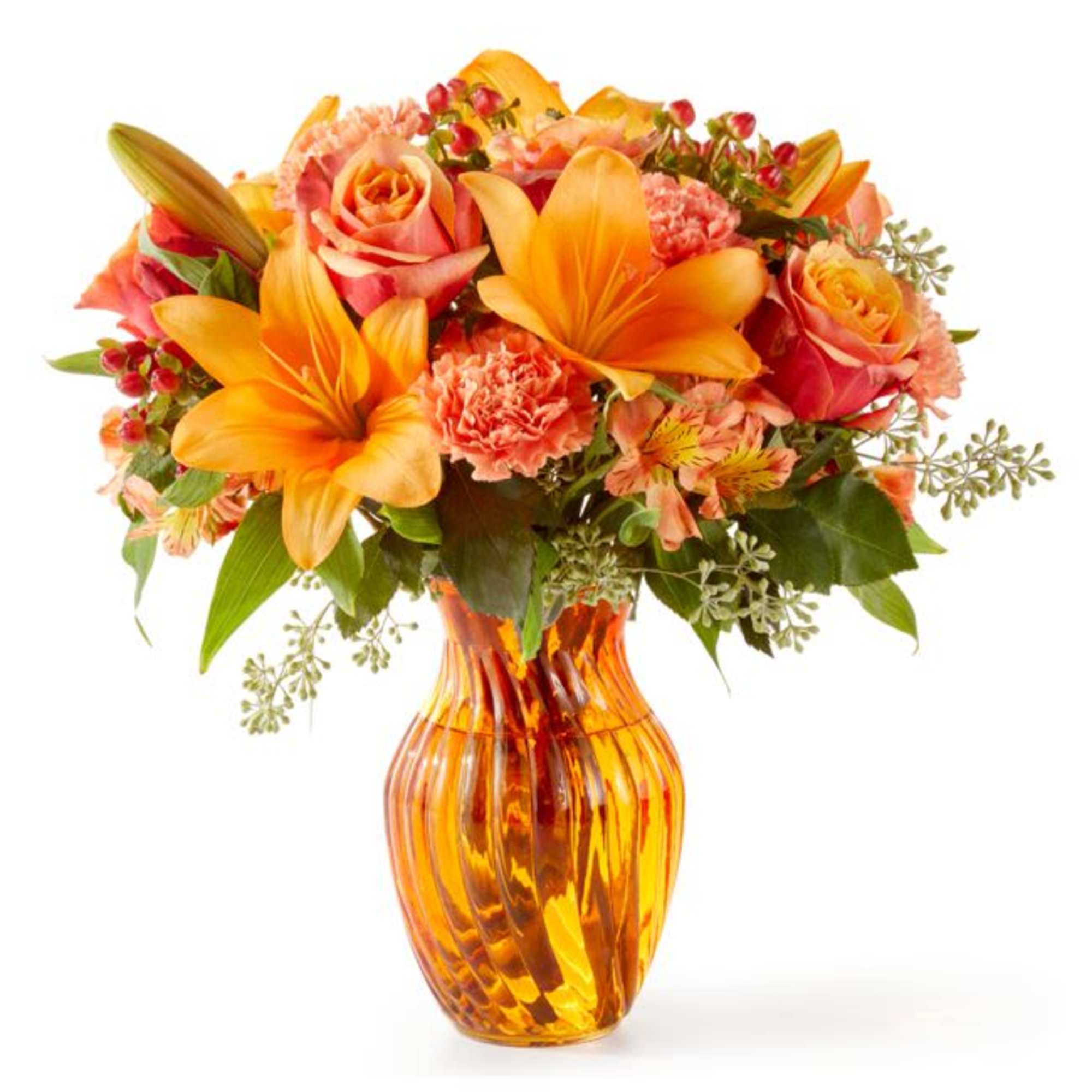Orange lilies and peach roses arranged in an amber glass vase
