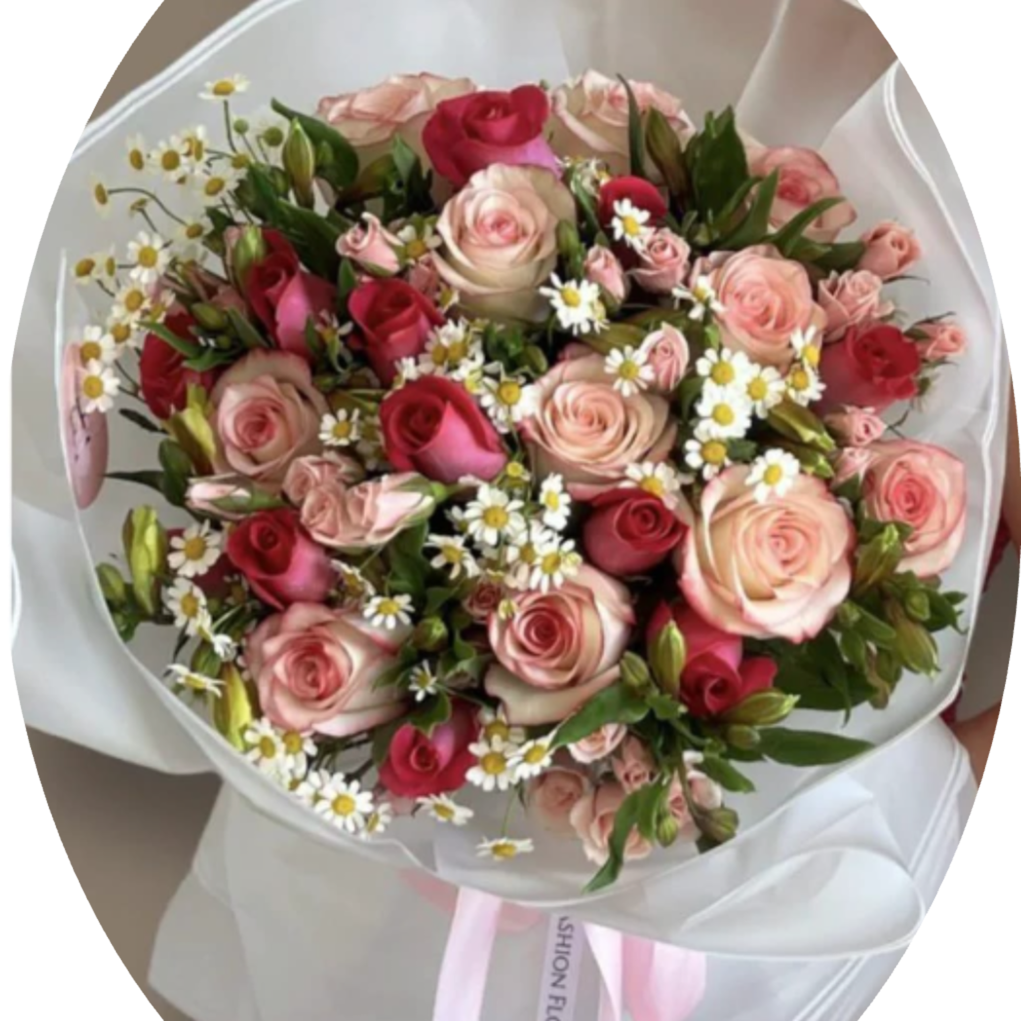 A lush hand-tied bouquet of blush pink and deep red roses framed