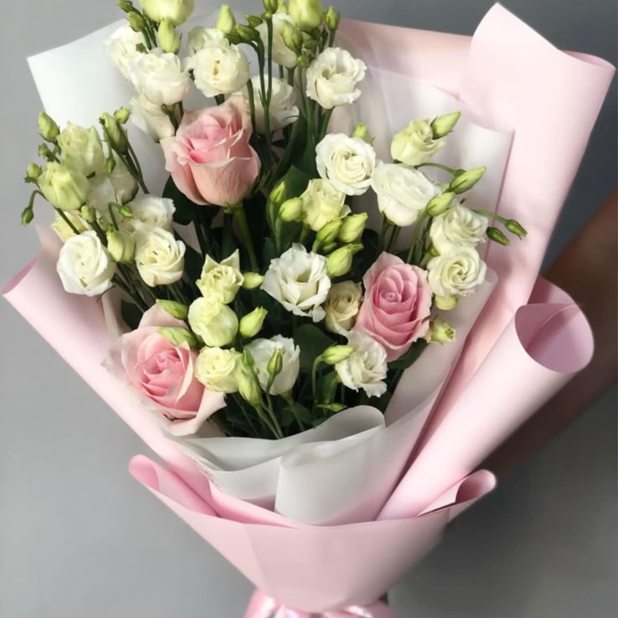 Soft pink roses paired with clusters of white lisianthus create a gently