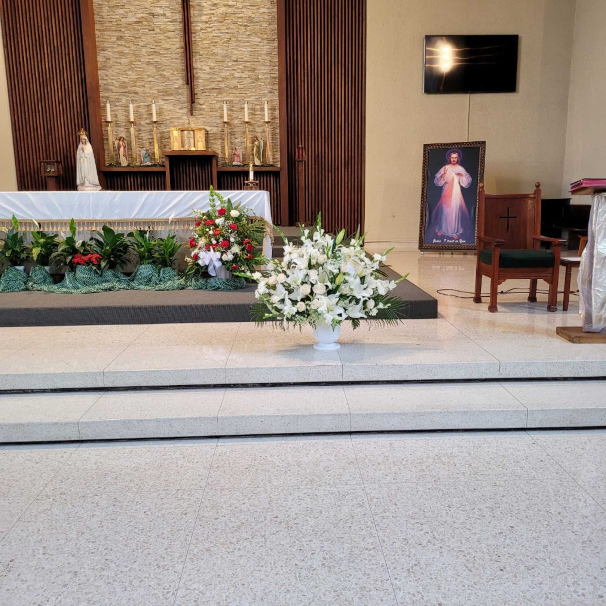 White floral arrangement in a vase at a church altar