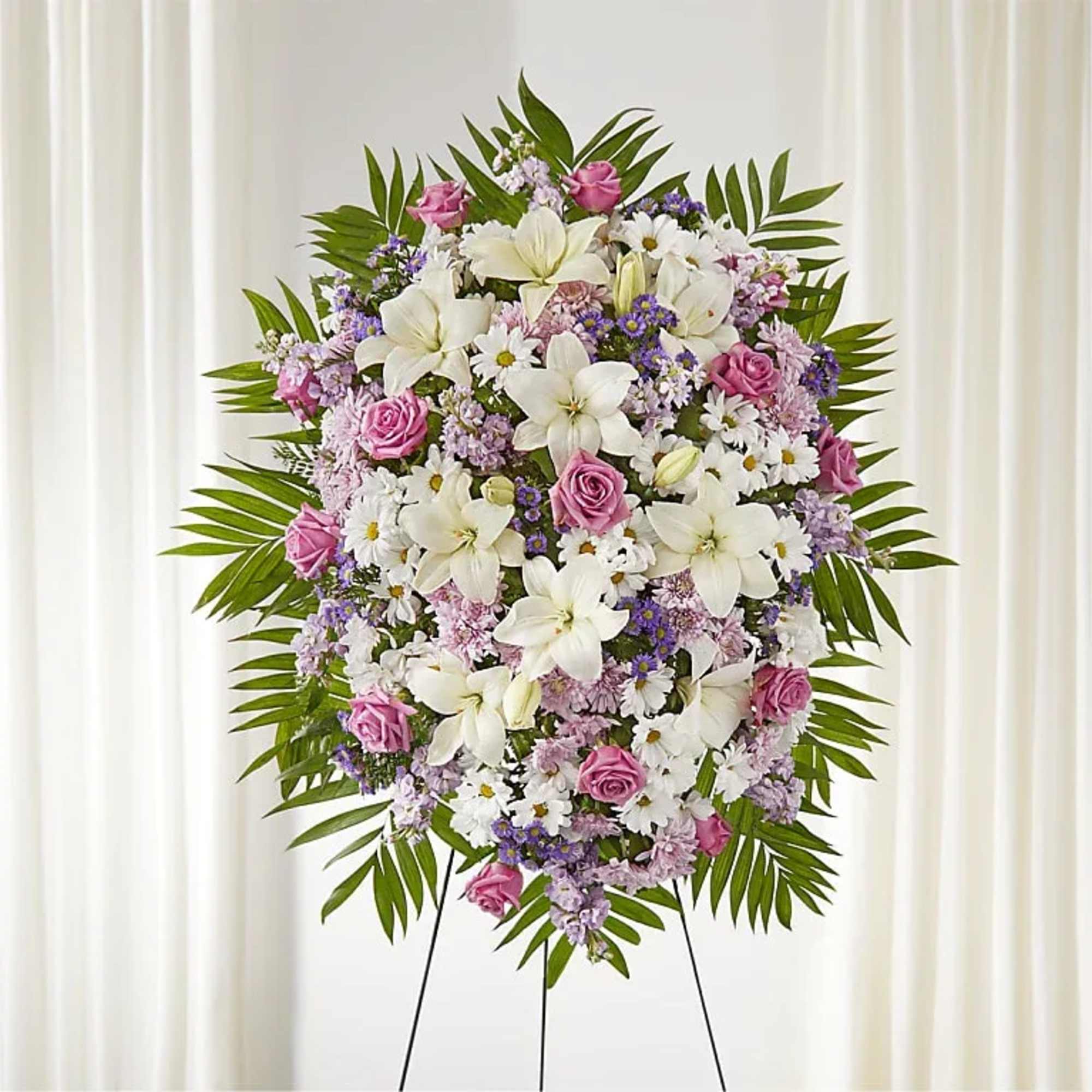 Standing floral wreath with white lilies, pink roses, and purple filler flowers