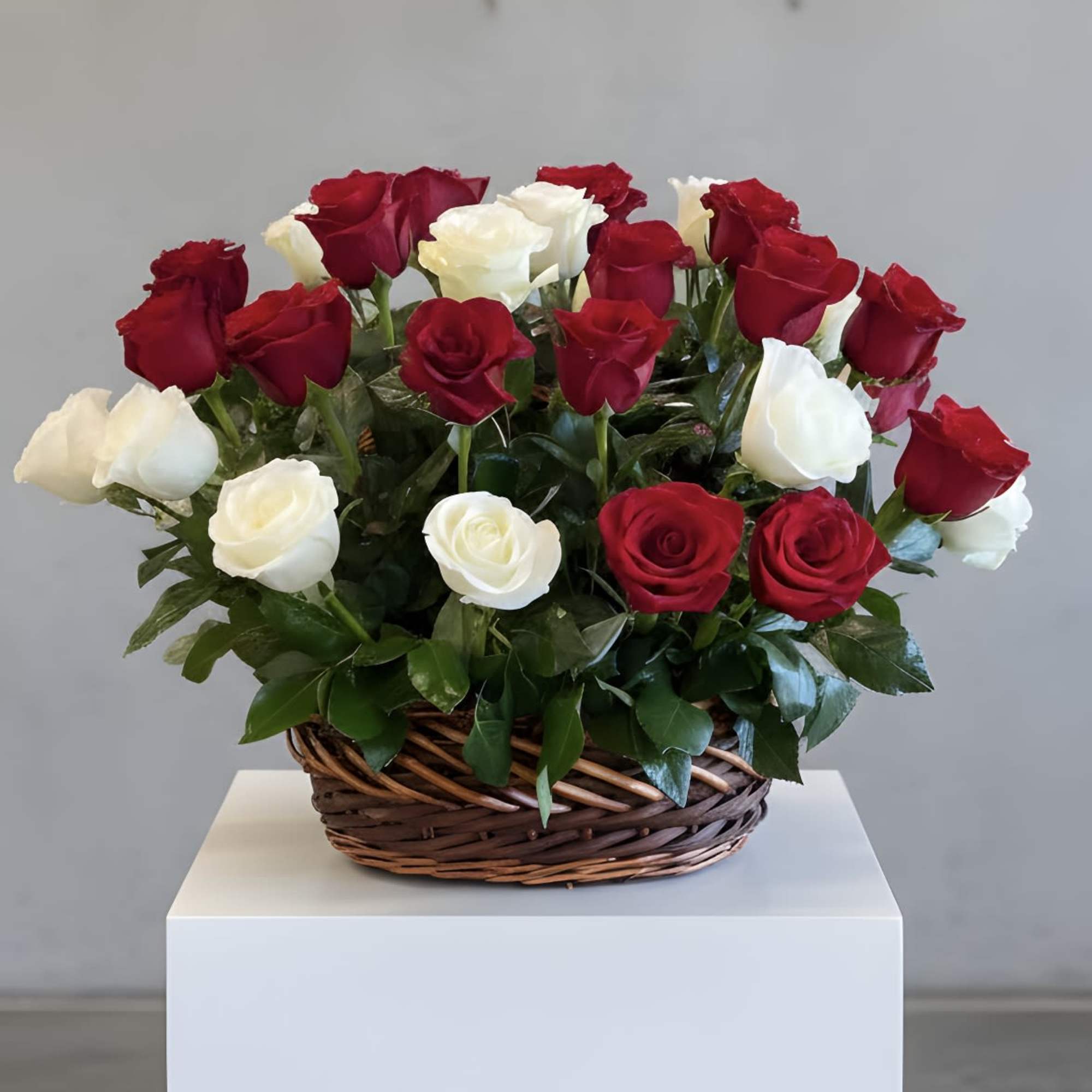 Basket of red and white roses on a white pedestal
