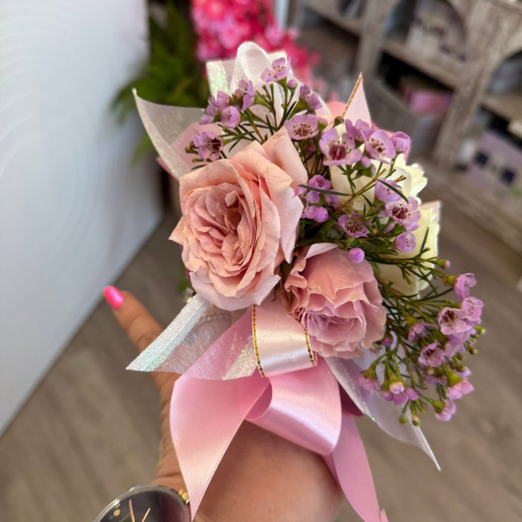 Small pink rose bouquet with purple filler flowers and a satin ribbon