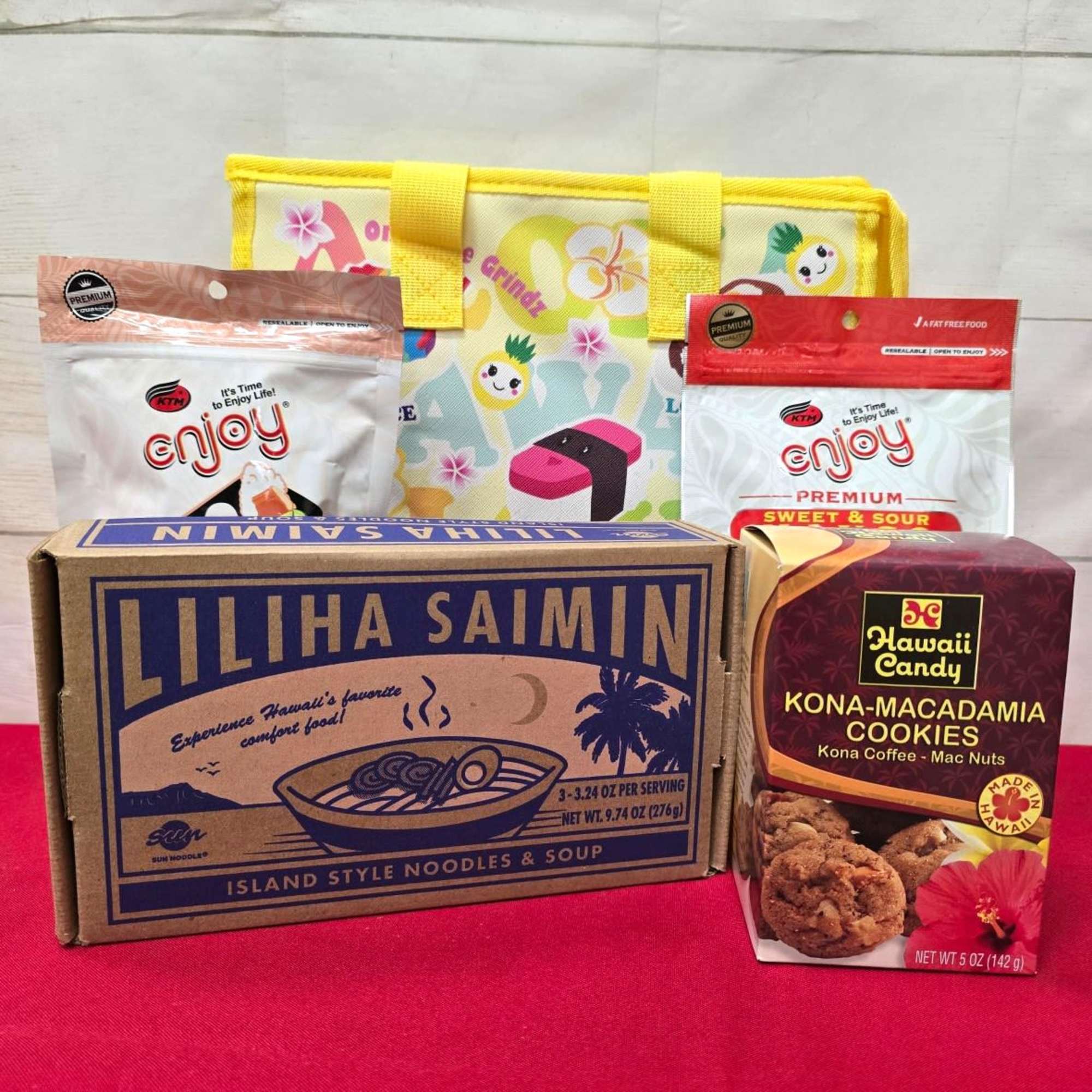 Hawaiian snack gift set with noodle box, cookies, snack bags, and a yellow printed tote.