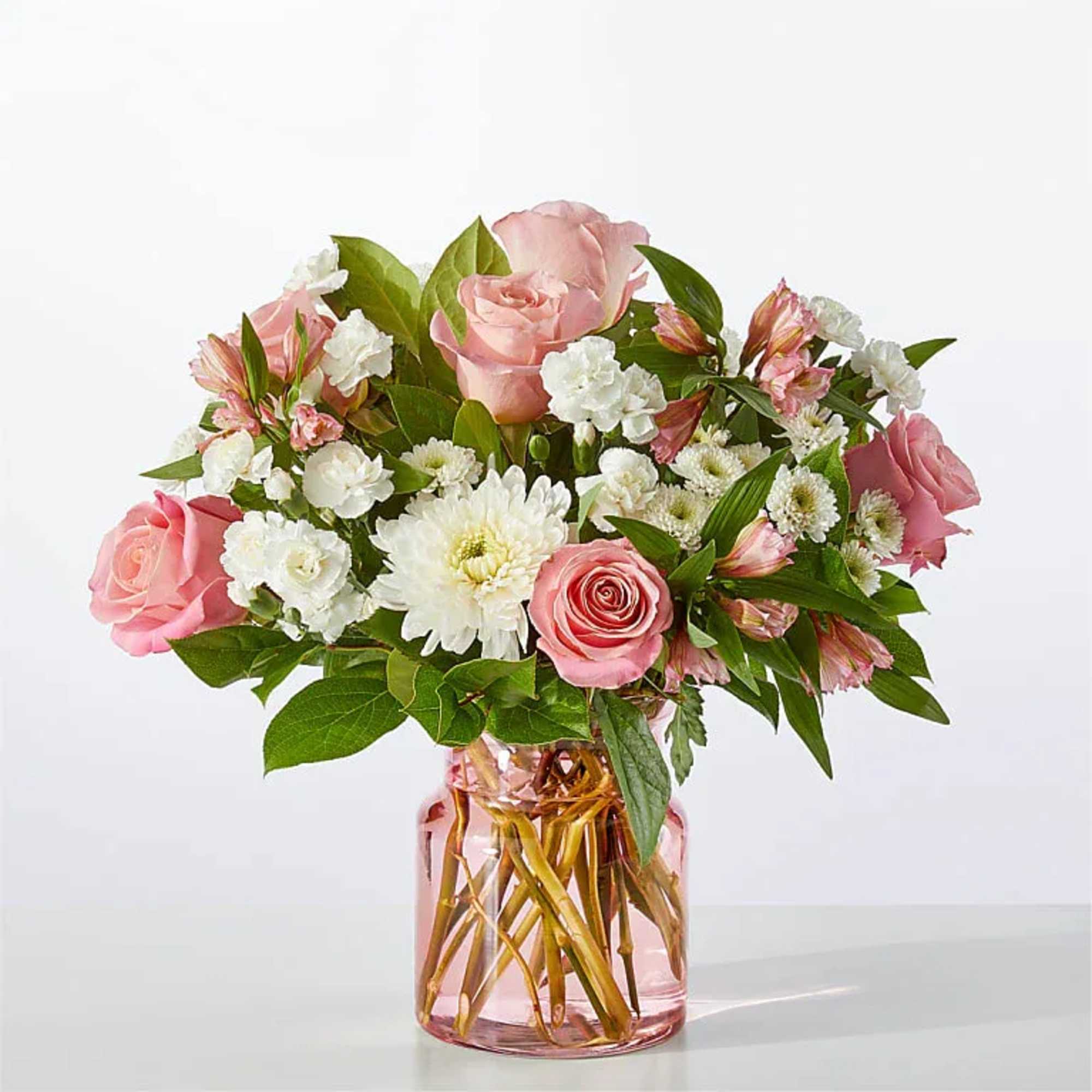 Pink roses and white flowers in a pink glass vase