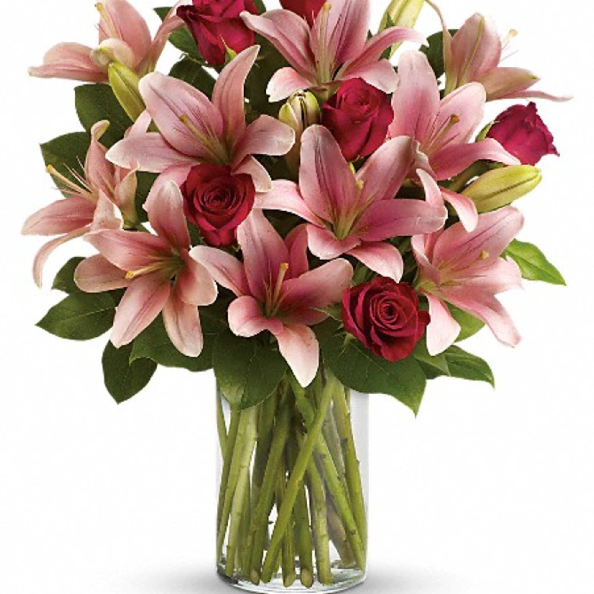 Pink lilies and red roses arranged in a clear glass vase