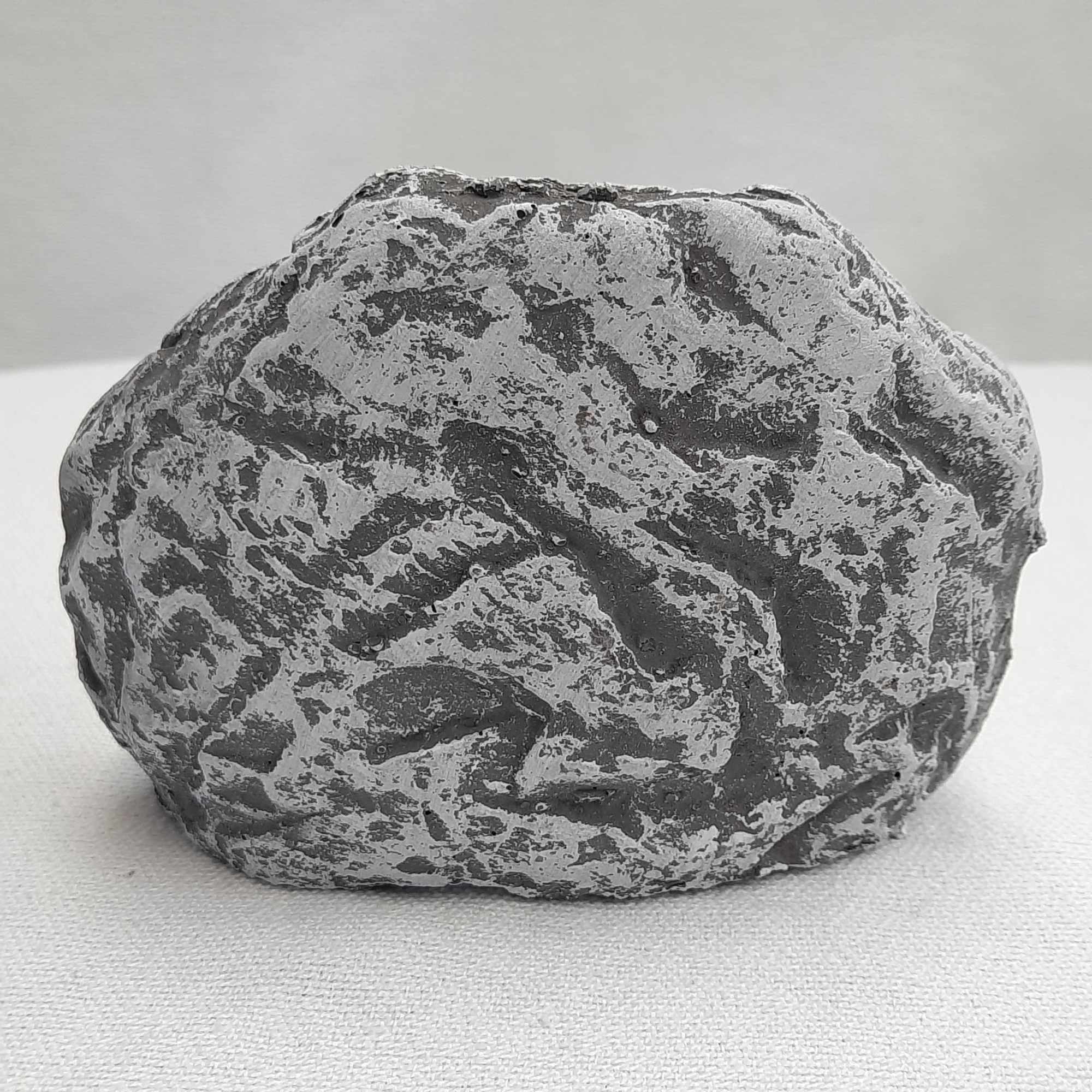 A gray textured decorative stone on a light surface