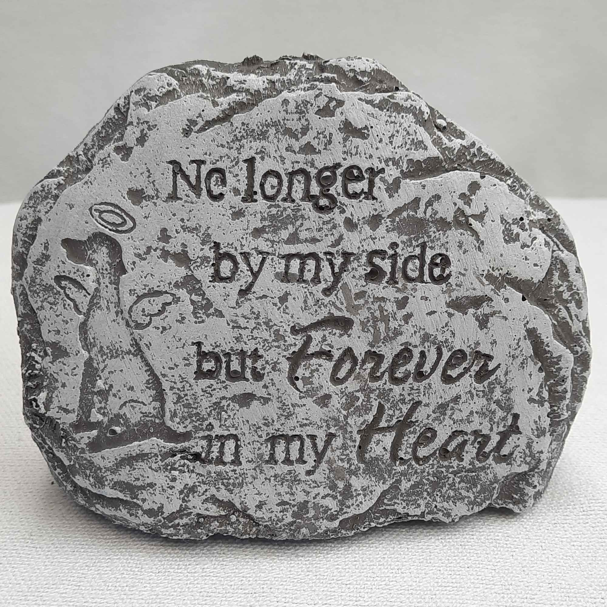 Decorative stone with engraved text and a small angel figure