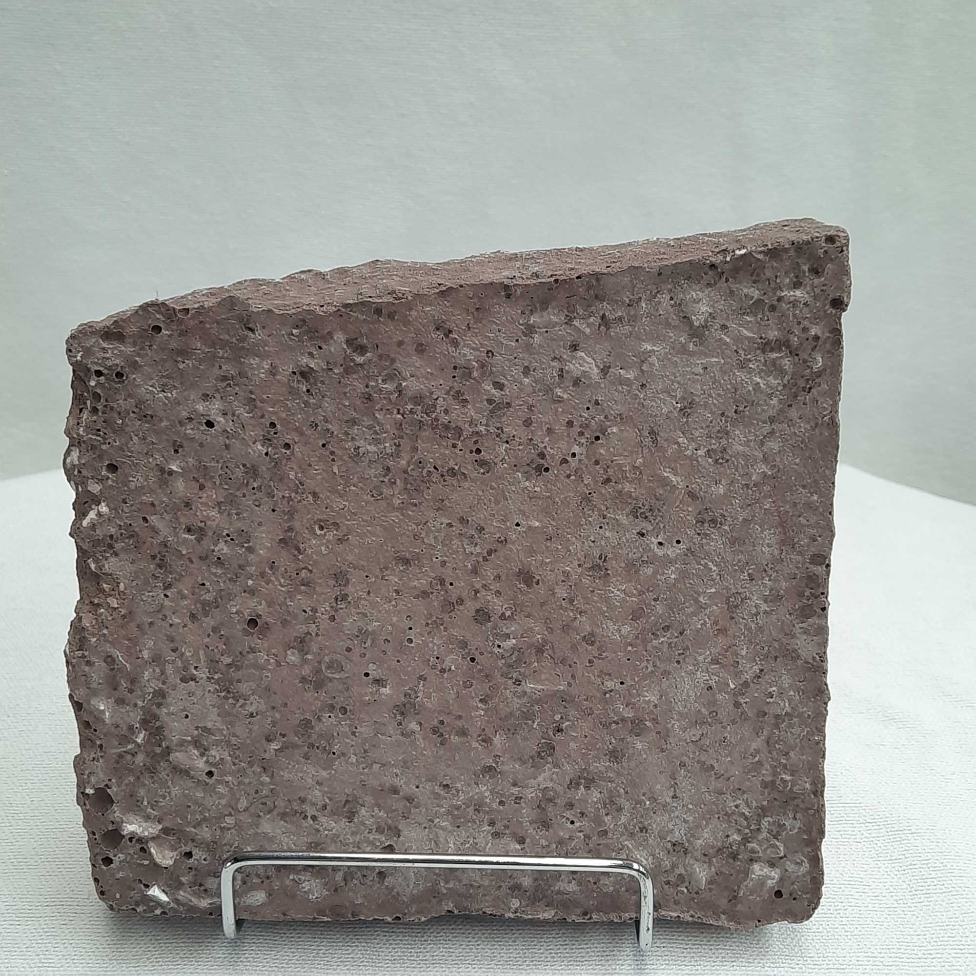 Rough rectangular stone slab on a display stand