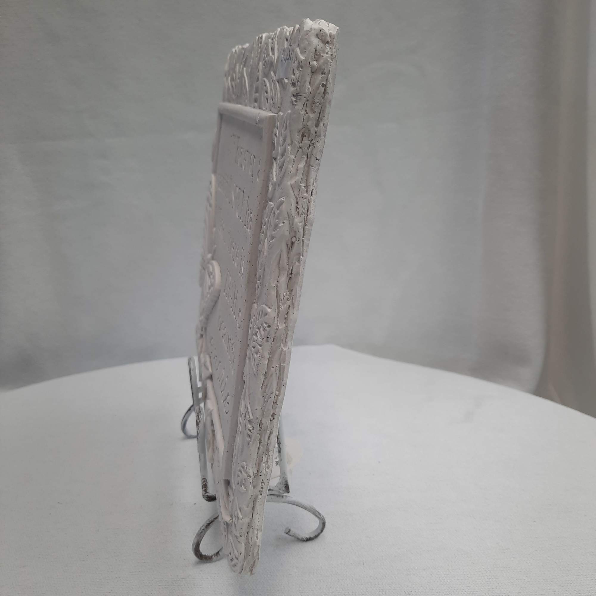 White decorative plaque on a metal stand